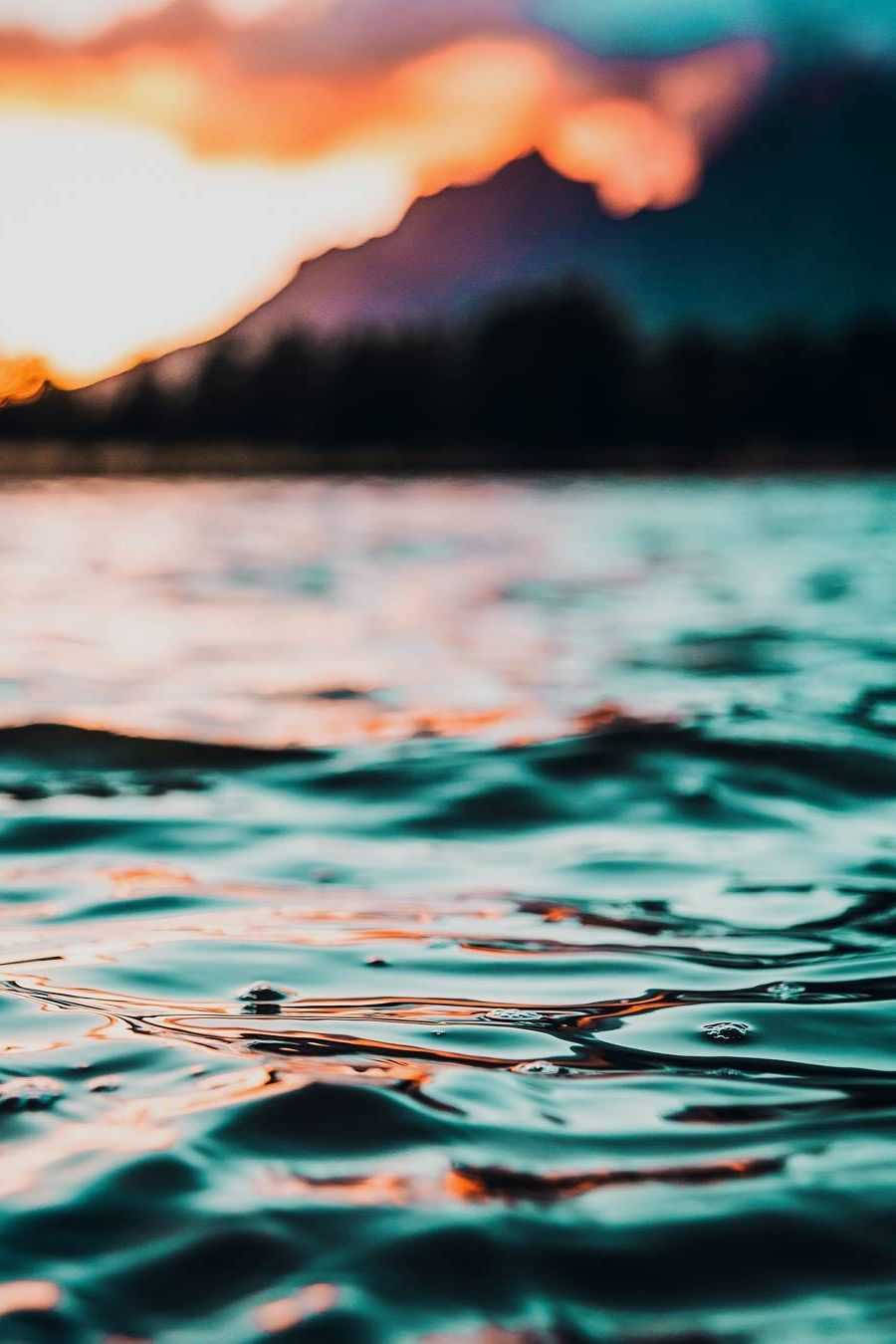 寧靜海洋壁紙 壁紙 — 夕陽的色彩在平靜的湖面上泛起漣漪，遠山在火紅的天空中映襯出剪影。