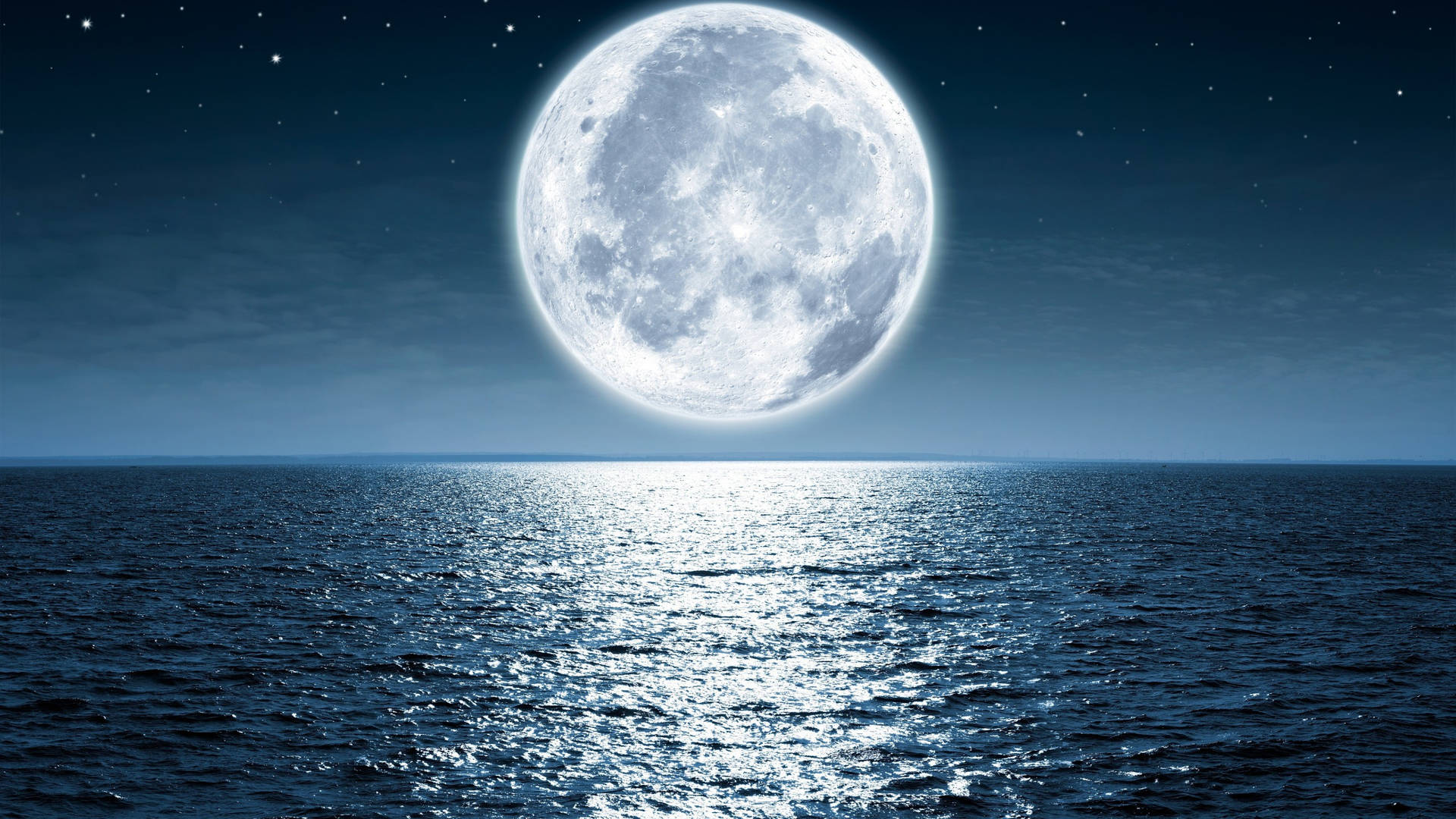 滿月映照在星空下平靜的海洋上