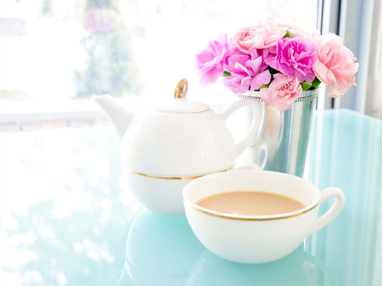 寧靜湖面的日落風景 壁紙 — 寧靜的早晨茶具擺設，白色茶壺和茶杯旁邊放著一瓶粉紅牡丹，放在淺藍色桌子上，靠近明亮的窗戶。