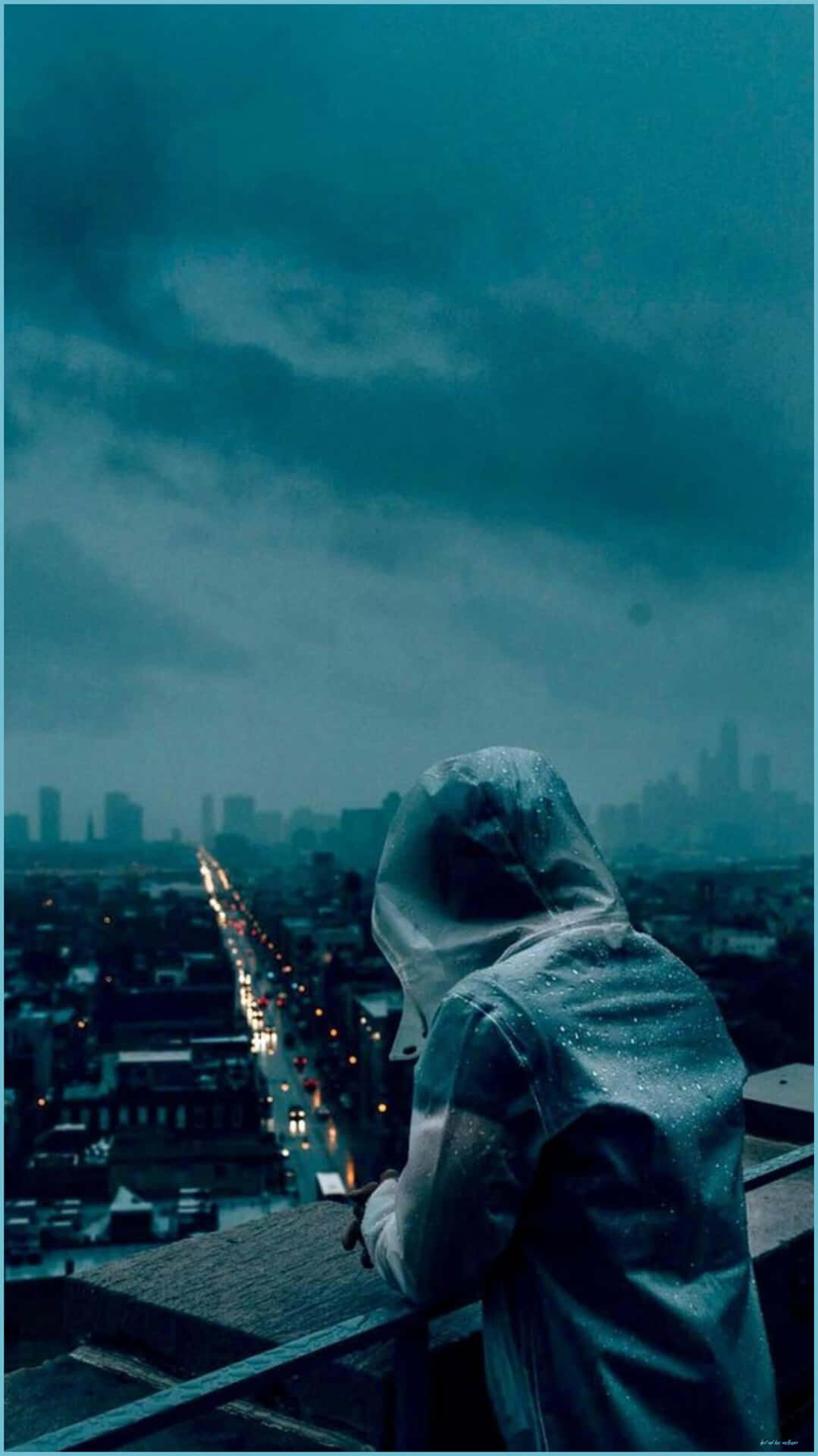 穿著雨衣的人俯瞰夜晚的雨城