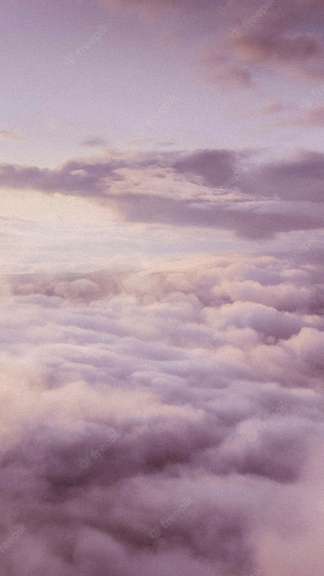 從上方觀看，暮色天空下柔和的紫色和粉紅色雲海。
