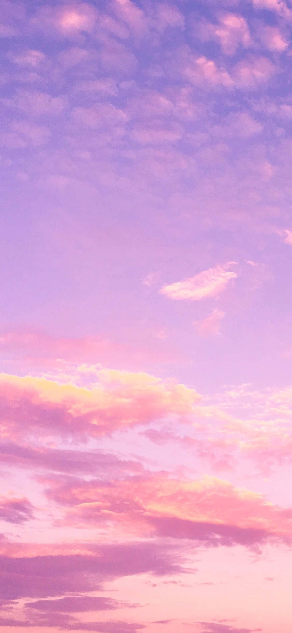 Pink Sky 桌布 壁紙 — 寧靜的天空，塗上柔和的粉紅色和薰衣草色雲彩，在日落時發光。