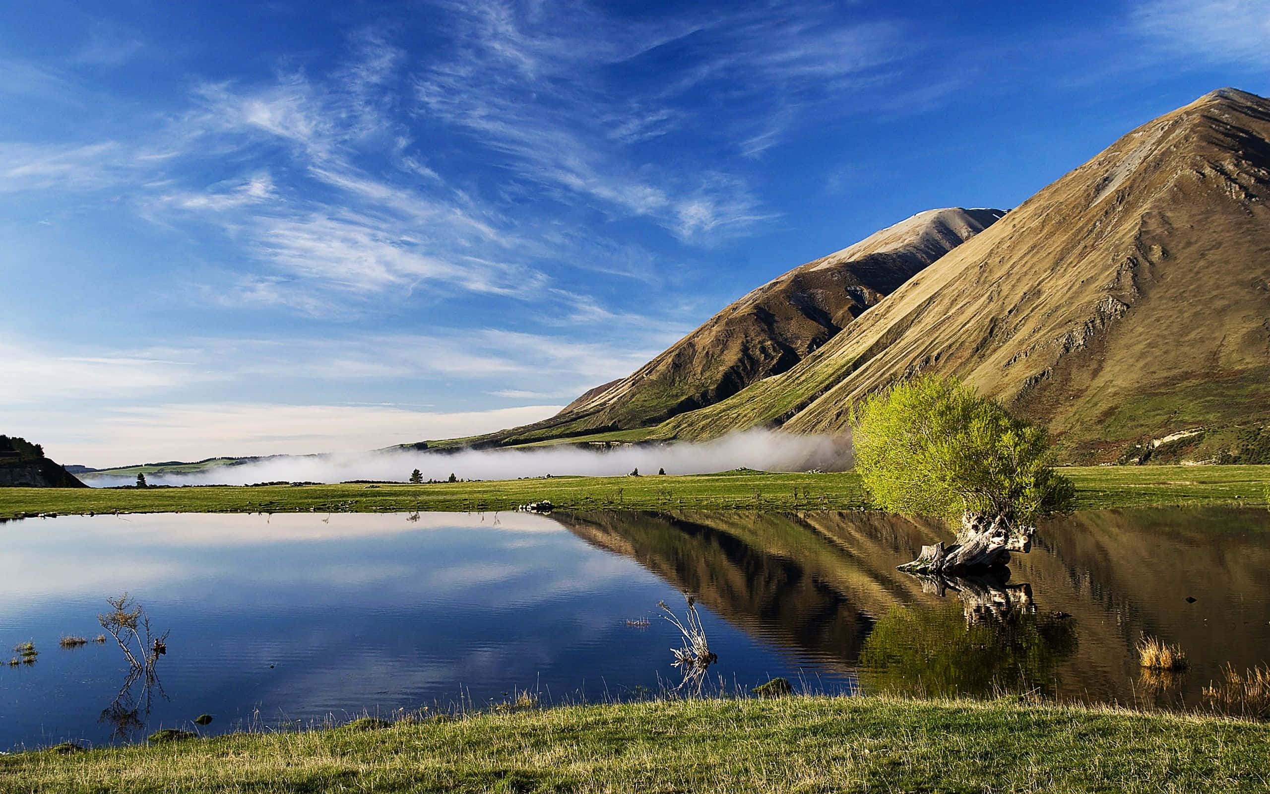 New Zealand 桌布 壁紙 — 寧靜的山湖在金色陽光下映照出鮮豔的藍天和霧氣繚繞的山谷。