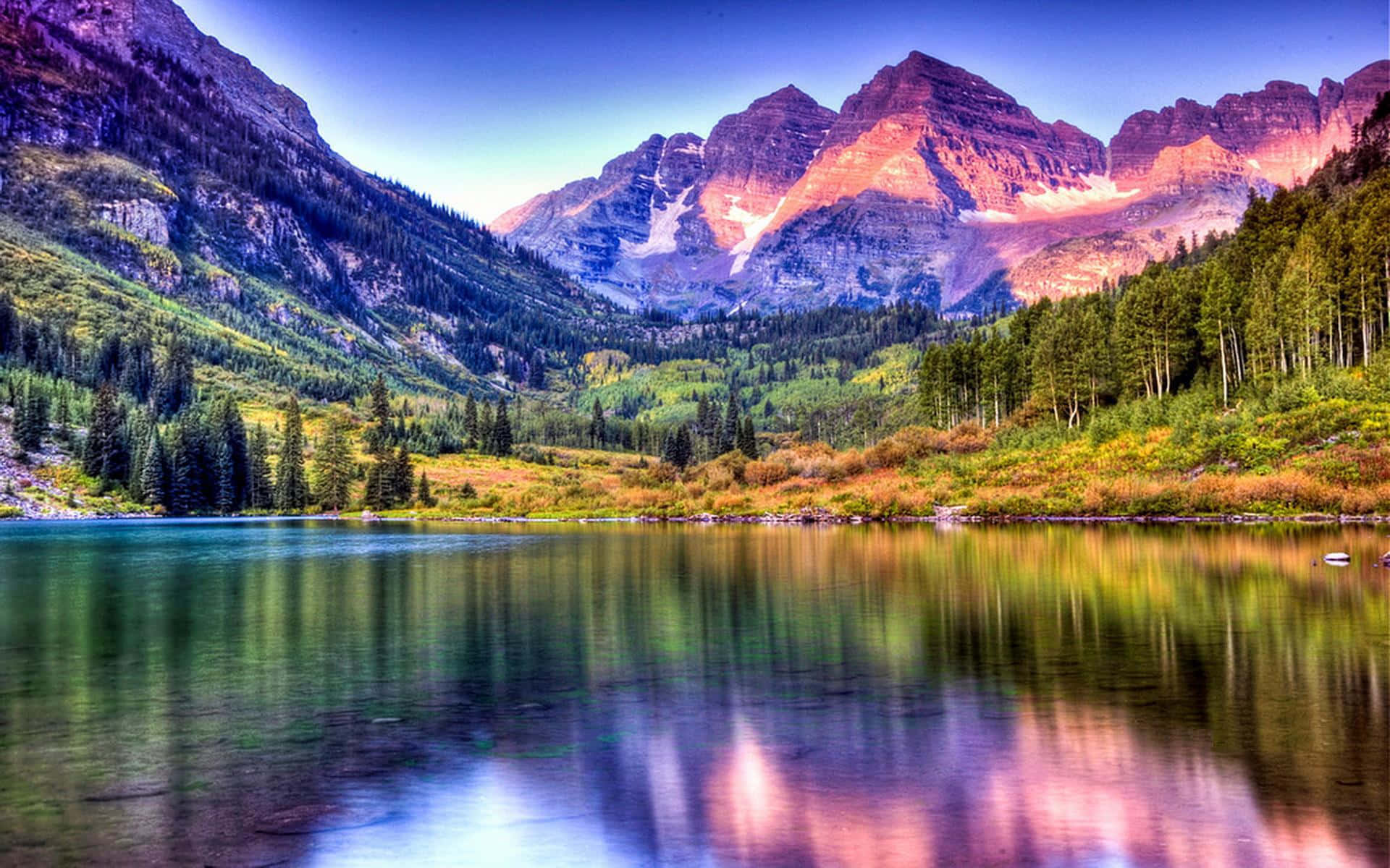 Colorado 桌布 壁紙 — 寧靜的山間湖泊映照著在日落時閃耀粉紅色和紫色的高聳山峰。