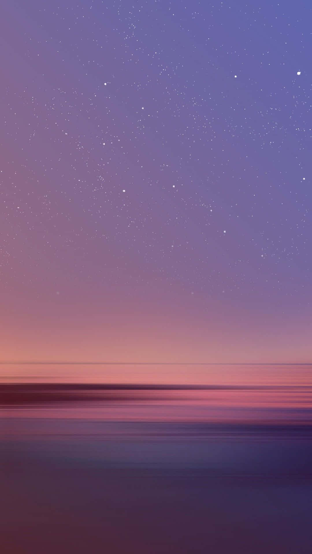 寧靜的水面與天空 壁紙 — 寧靜的暮色天空，星星逐漸融入紫色、粉紅色和藍色的漸變中，映照在平靜的水面上。