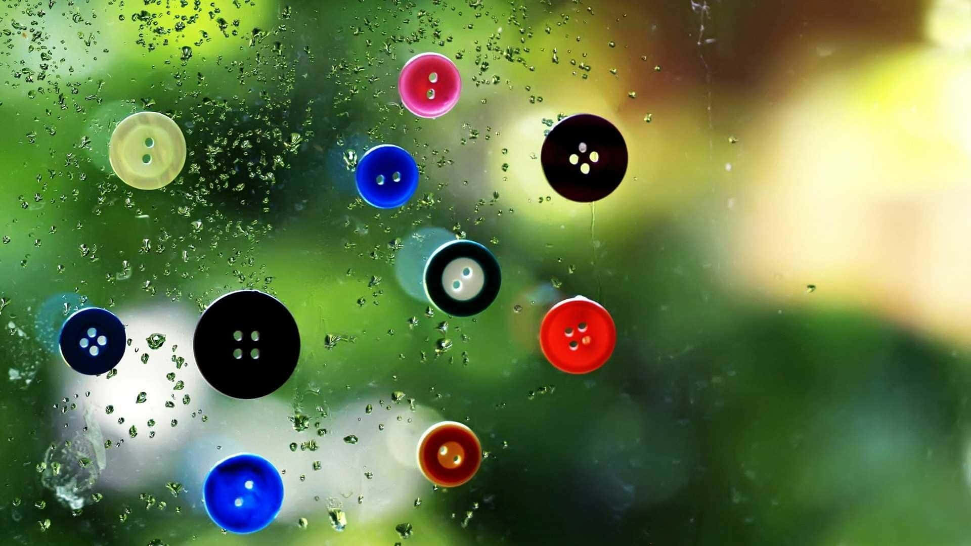 雨滴和鈕扣在玻璃窗上，背景為綠色。