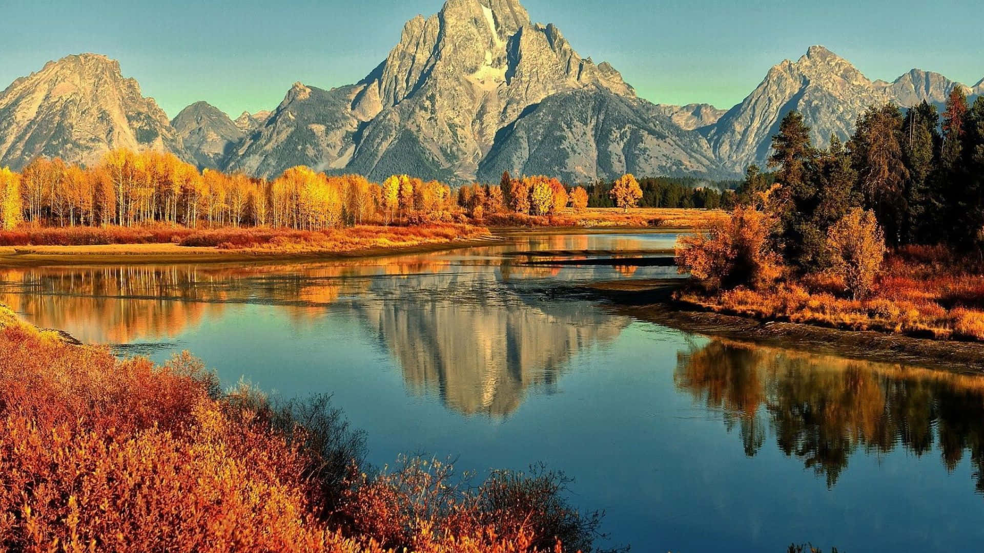 Fall Lake 桌布 壁紙 — 寧靜的秋日河流映照著高聳的花崗岩山峰和金色的白楊樹，在清澈的藍天下。