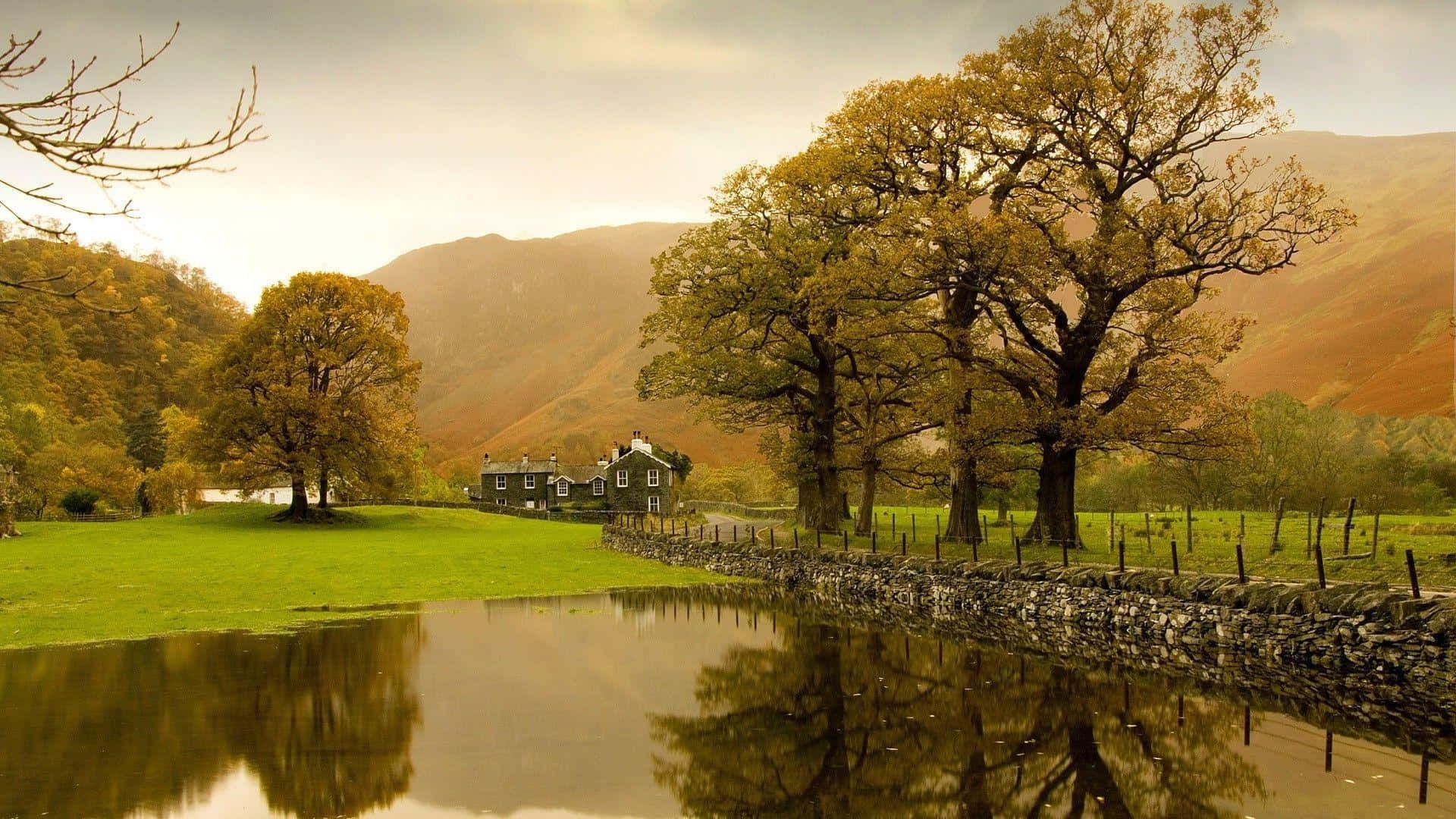 Modern Farmhouse 桌布 壁紙 — 寧靜的秋日風景，石牆池塘映照著金色的樹木和遠山，天空柔和。