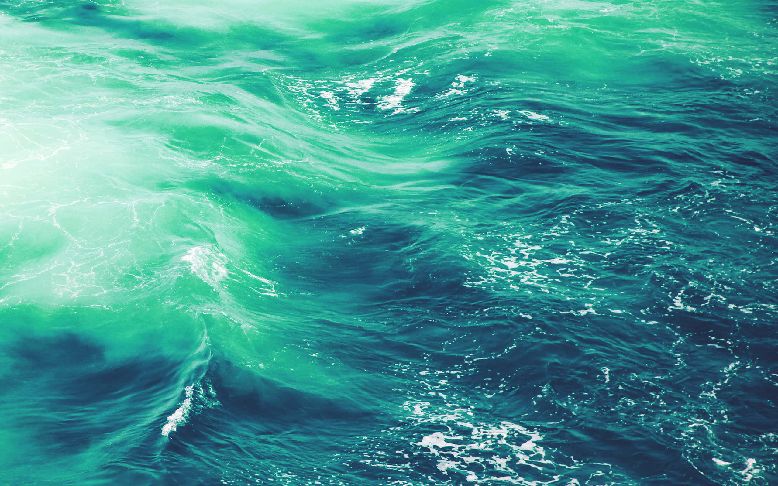 寧靜的藍色海洋水景 壁紙 — 充滿活力的綠松色海浪在明亮的陽光下泛起白色泡沫。