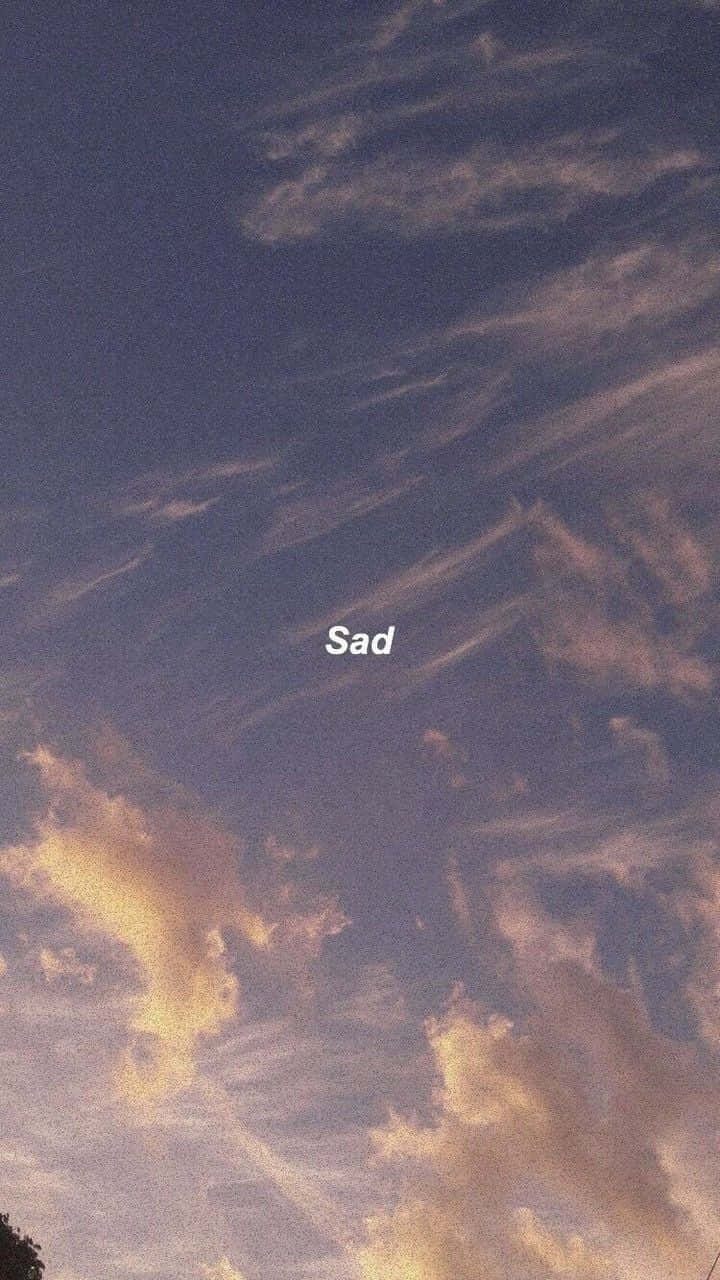 戲劇性的天空，黃昏時金色雲彩，疊加單詞 sad。