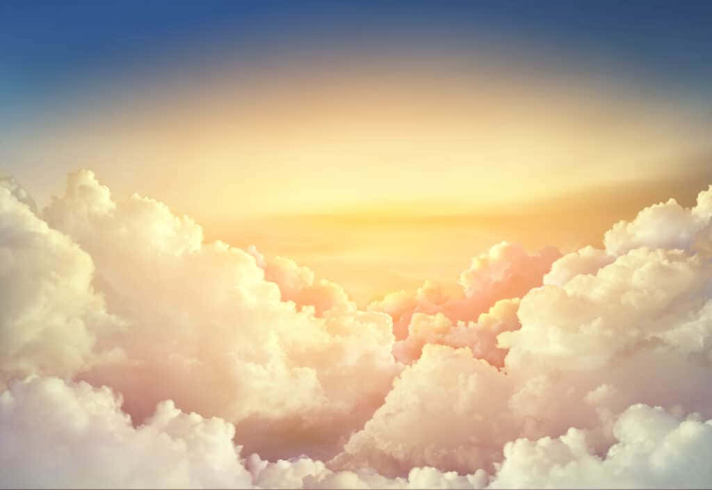 寧靜與美麗的天堂之景 壁紙 — 日出時分，廣闊的蓬鬆雲朵在柔和藍天的映襯下閃耀著溫暖的金色光芒。