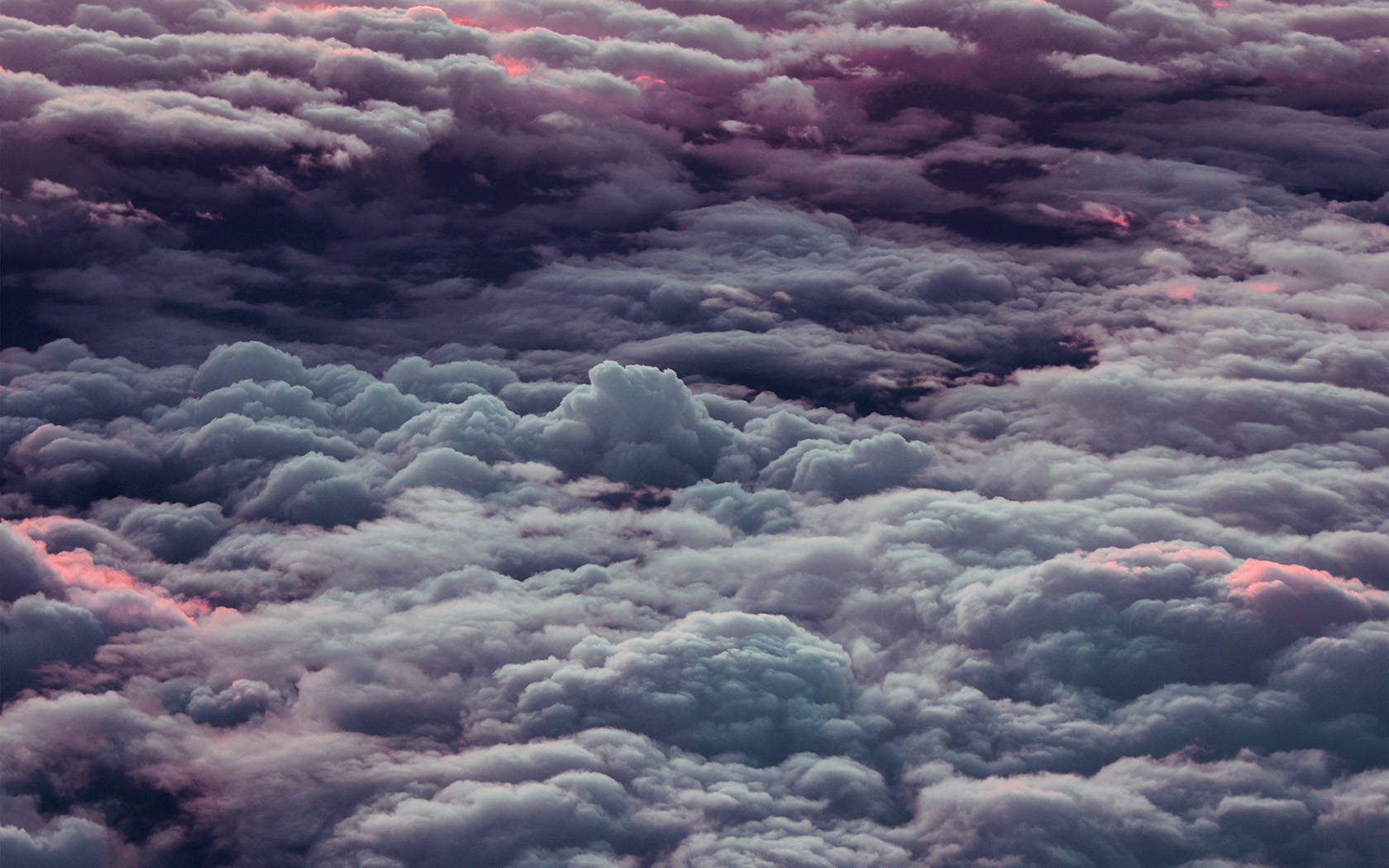 寬廣的雲海桌面壁紙 壁紙 — 黃昏時分，從空中俯瞰帶有紋理的雲彩，呈現柔和的粉紅色和藍綠色調。