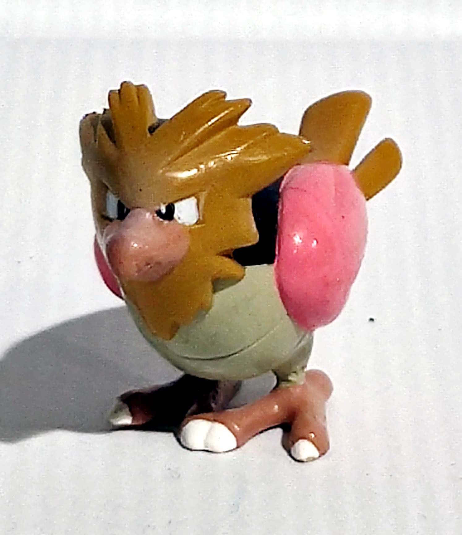 寶可夢 Spearow 模型 壁紙 — 一隻光澤塑膠玩具精靈寶可夢大嘴雀公仔，在純白背景前擺出姿勢。