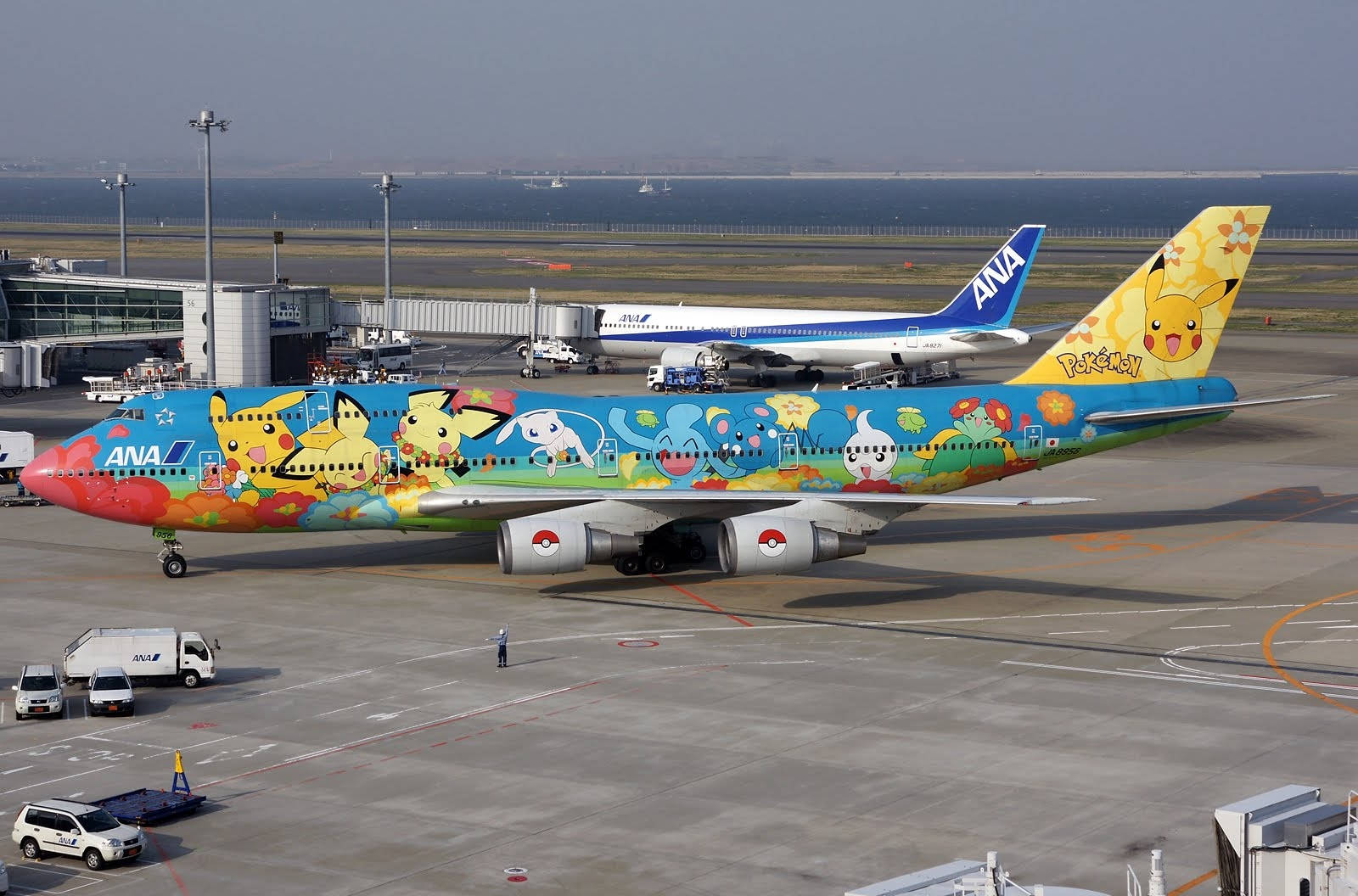 在機場停機坪上，裝飾有寶可夢角色的彩色ANA飛機。