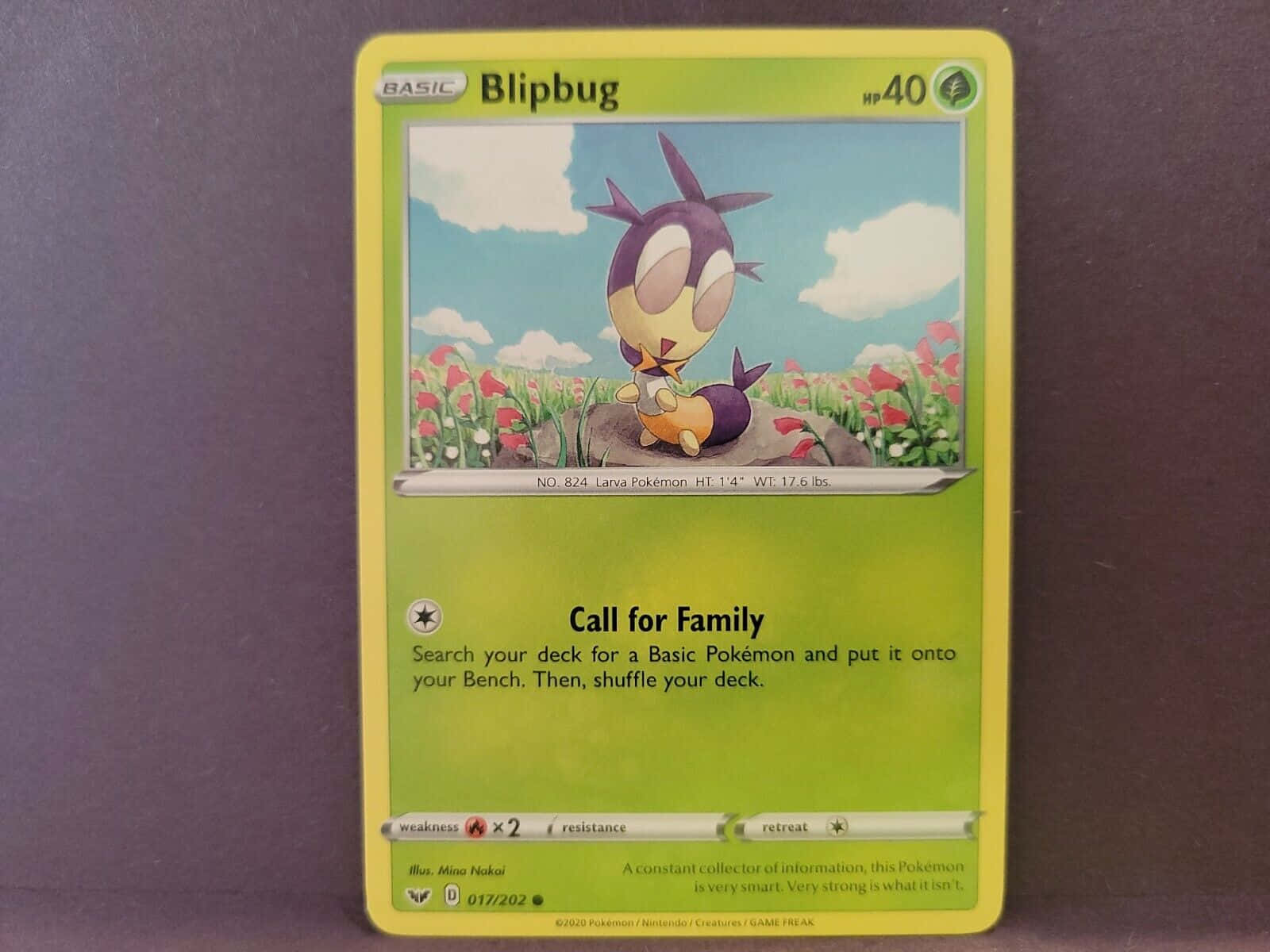 寶可夢布莉布莉黃色遊戲卡 壁紙 — 一張黃色寶可夢卡，上面有Blipbug坐在岩石上，周圍是紅色花田，背景是藍天白雲。
