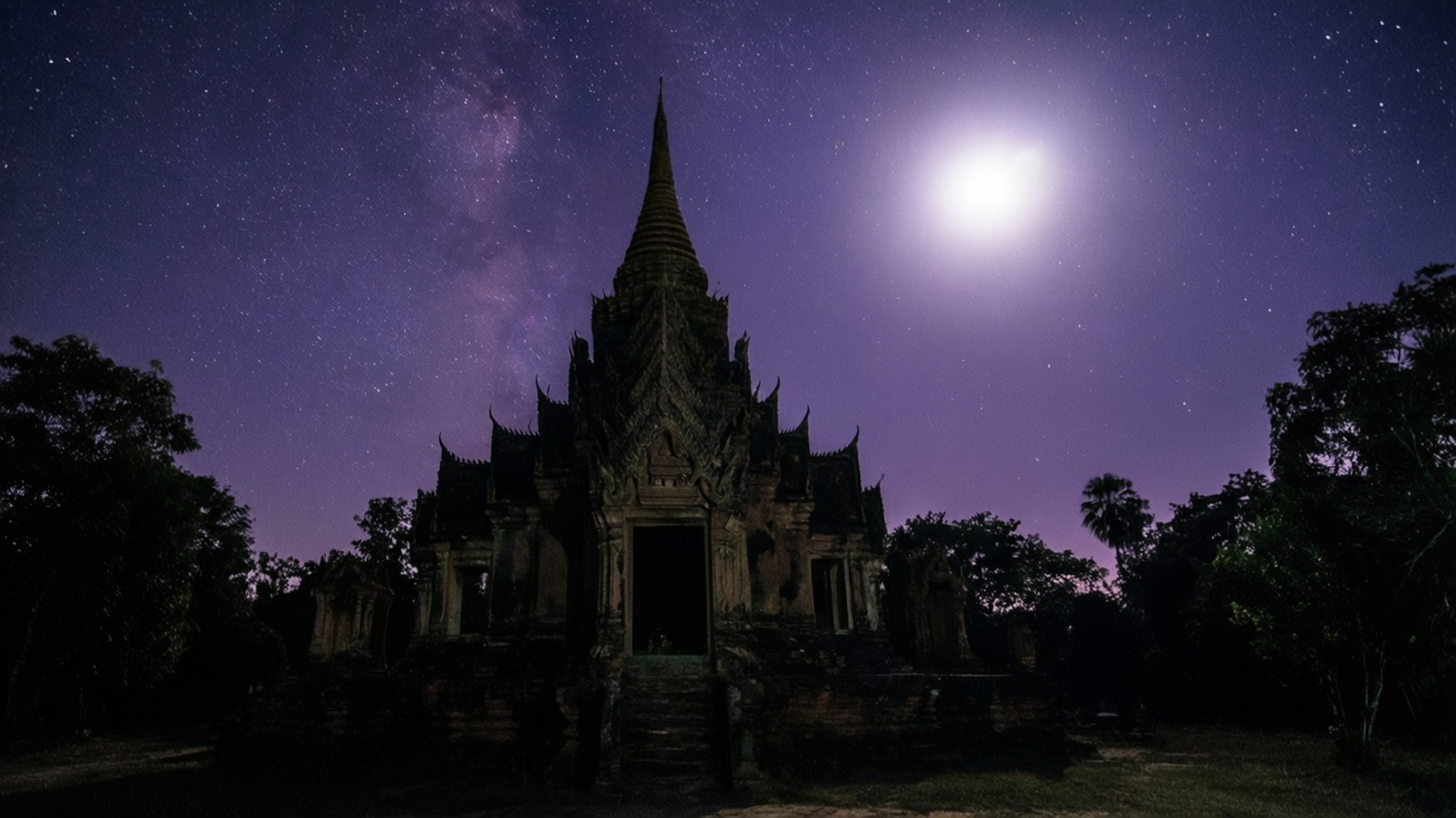 寶石寺廟之夜 壁紙 — 古老寺廟的剪影，在繁星點點的夜空下，明亮的月亮和銀河在上方閃耀。