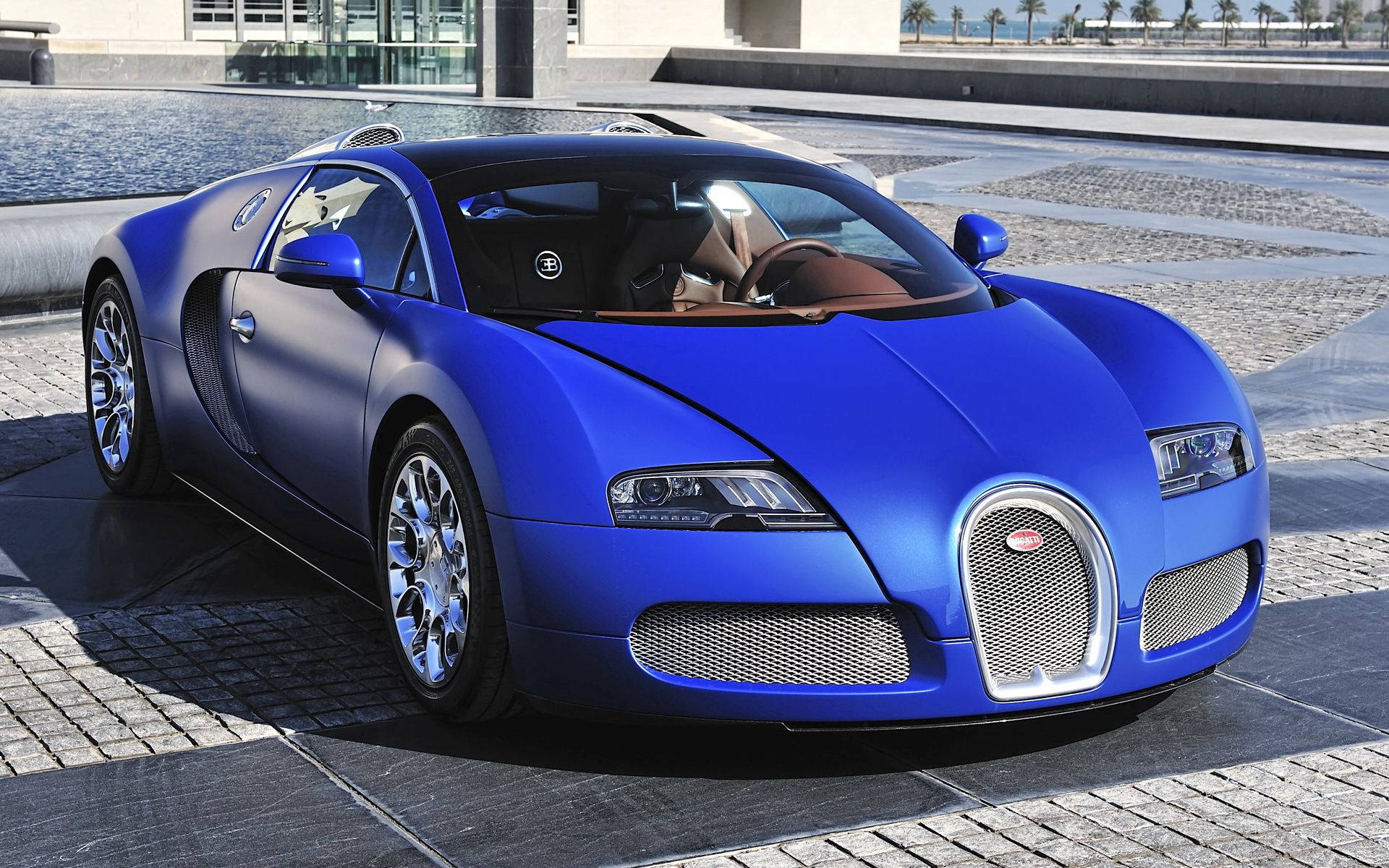 啞光藍色Bugatti Veyron停在水景附近的石頭廣場上。
