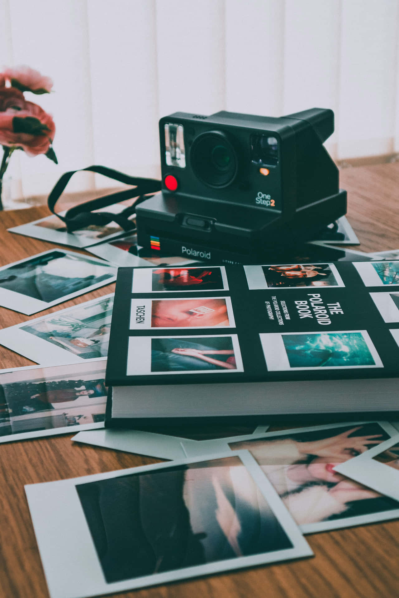 復古Polaroid相機和相簿被即影即有照片包圍在木質表面上。