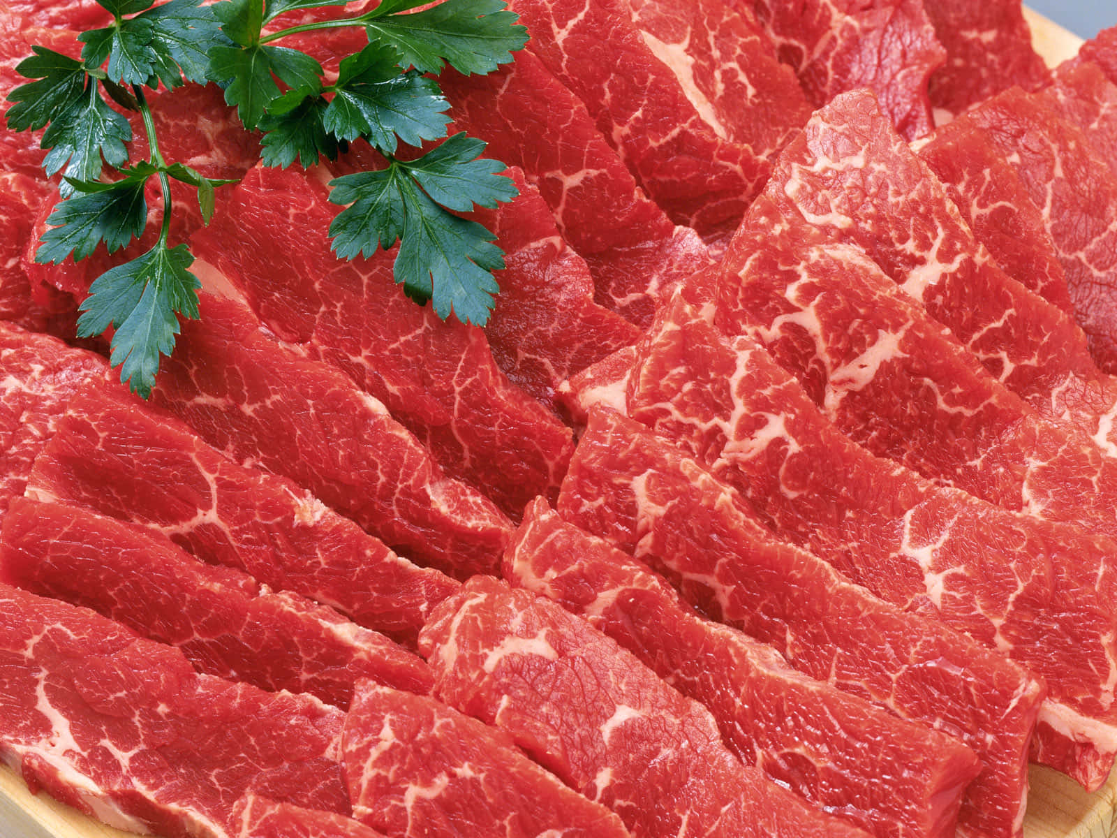 Red Meat 桌布 壁紙 — 將大理石紋生牛肉片整齊排列在木板上，並以新鮮歐芹裝飾。