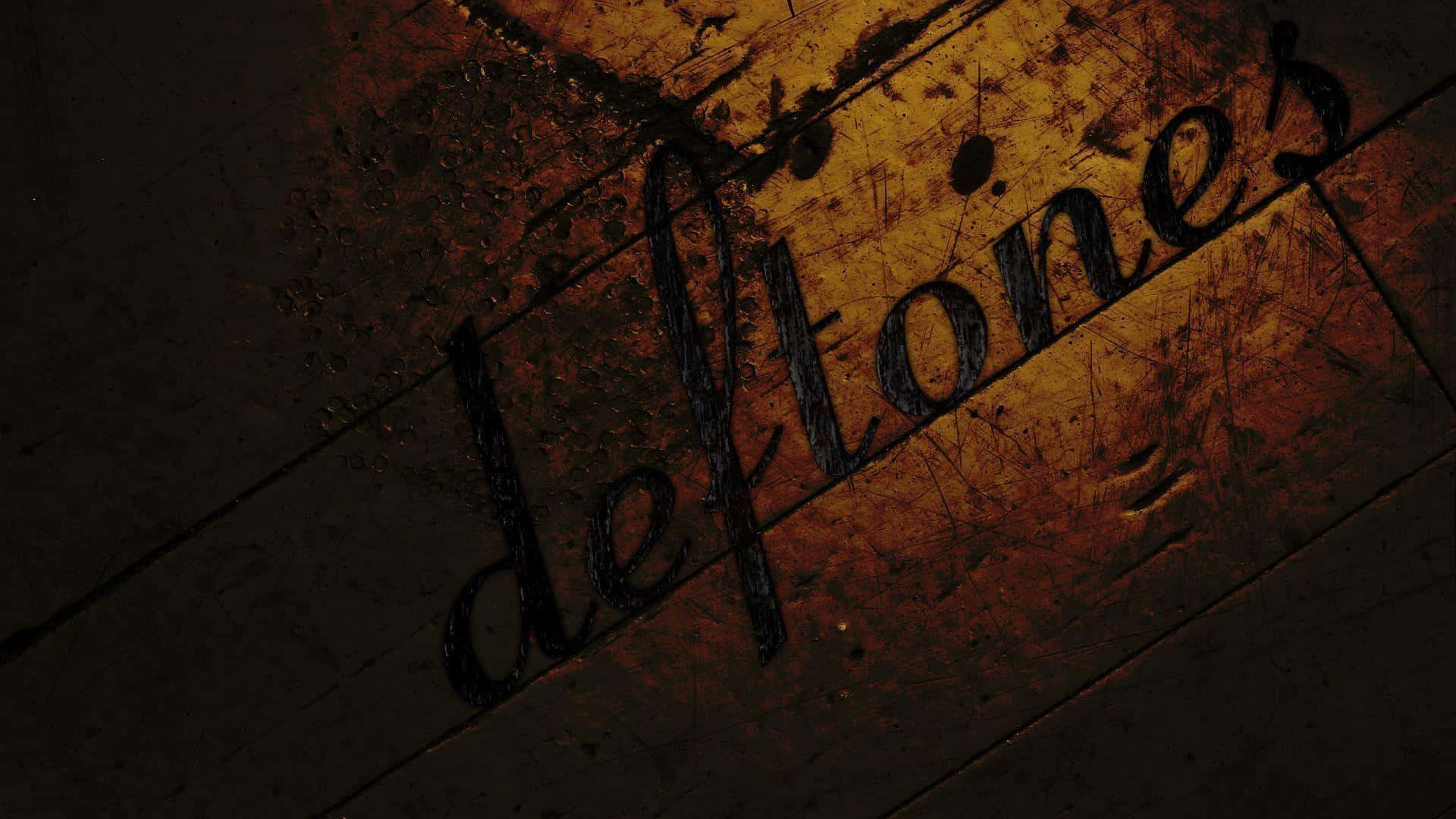 將金屬樂推向新高度：Deftones HD 壁紙 — 「deftones」這個字以黑色刮痕出現在經風化的木質表面上，伴隨溫暖的橙色燈光。