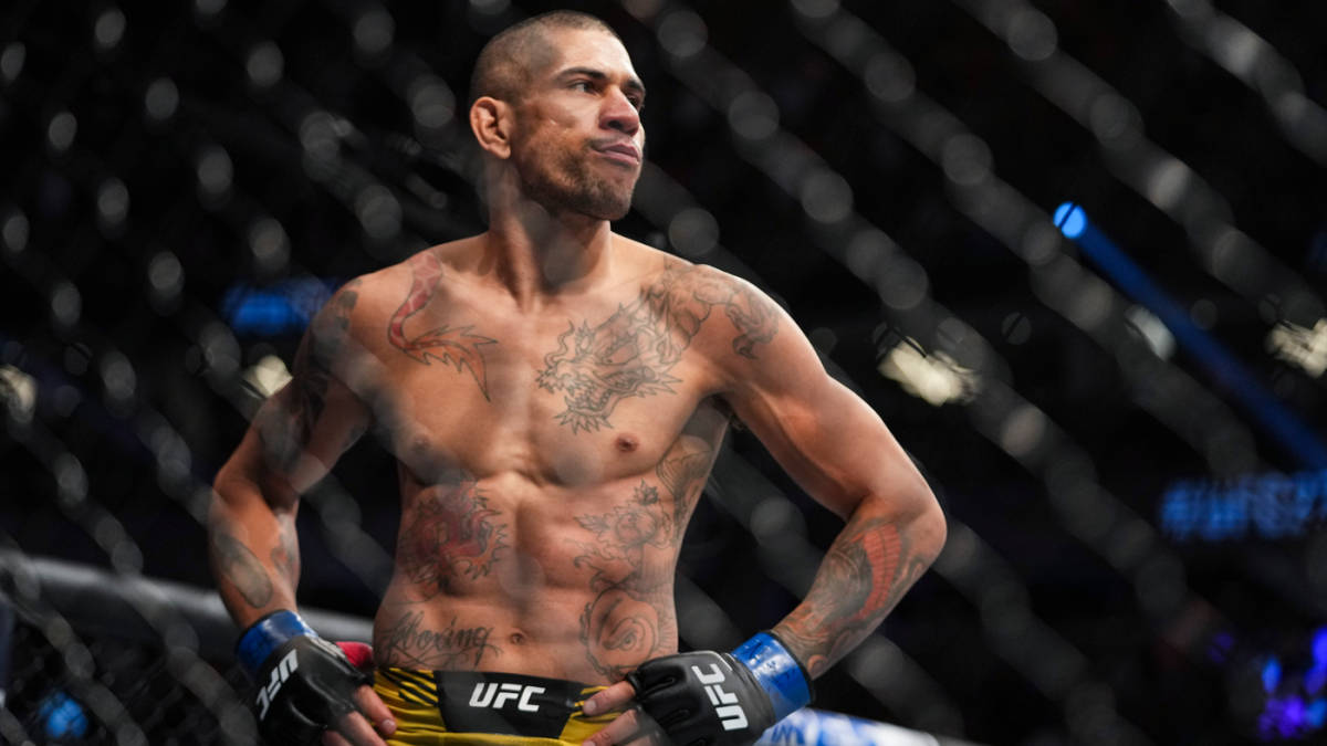 專業戰士亞歷克斯·佩雷拉自信站立 壁紙 — 一位有紋身的UFC拳手在明亮的場館燈光下，雙手叉腰自信地站在八角籠中。