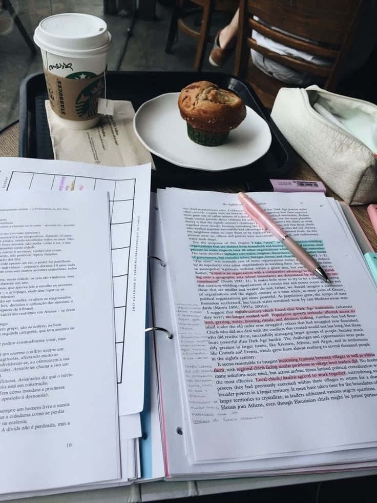 專注學習 壁紙 — 一個舒適的學習場景，木桌上放著打開的教科書、咖啡杯和一支筆。