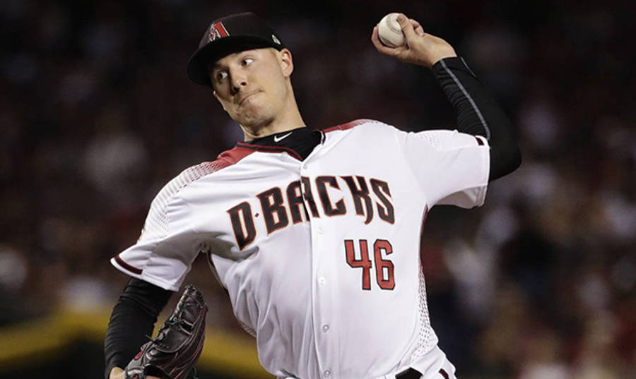 專注的帕特里克·科賓 壁紙 — 一位身穿D'Backs球衣的棒球投手在夜間比賽中，於球場燈光下準備投球。