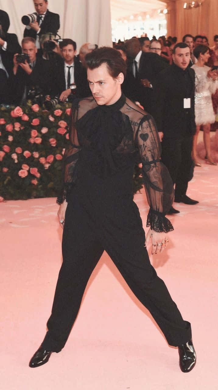 Met Gala 桌布 壁紙 — 尊尼特普在粉紅地毯上穿著透視黑色服裝，被攝影師和花卉佈置包圍，擺出大膽姿勢。