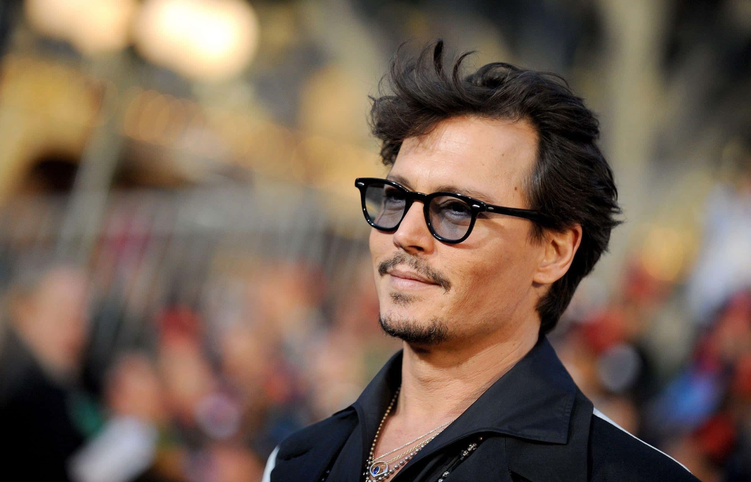 Johnny Depp 桌布 壁紙 — 尊尼特普戴著黑框眼鏡和深色外套，在擁擠的活動中望向鏡頭外。