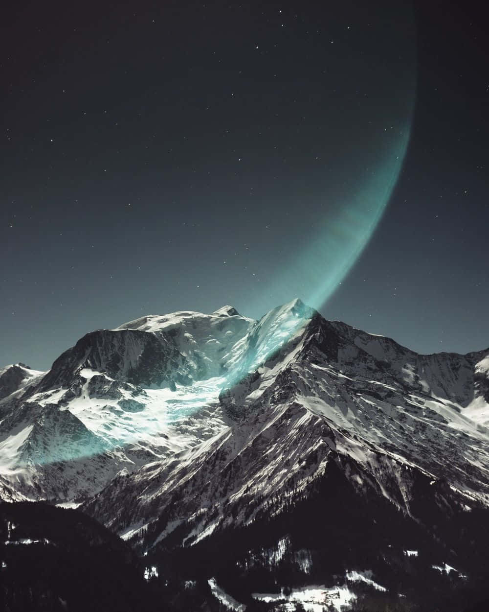 尋找寧靜，平衡身心，重拾能量 壁紙 — 積雪的山峰在星空下閃耀，發光的青綠色極光在山脊上拱起。