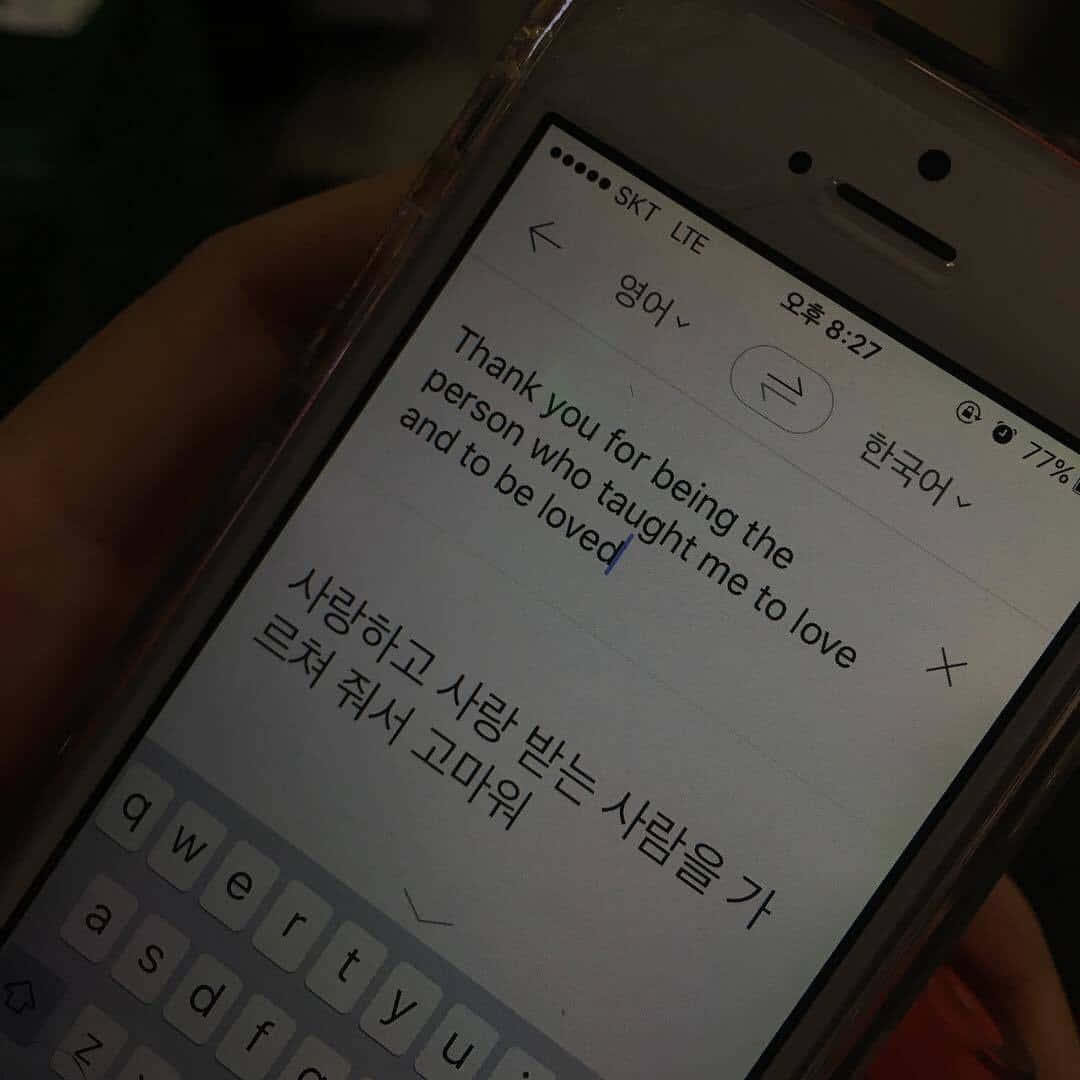手拿著手機，在黑暗環境中顯示雙語愛情訊息