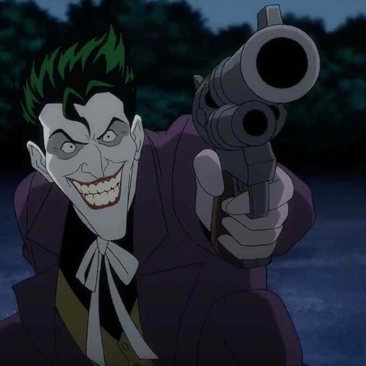 The Killing Joke 桌布 壁紙 — 小丑在黑暗的戶外環境中瘋狂地咧嘴笑著，同時將左輪手槍瞄準觀眾。
