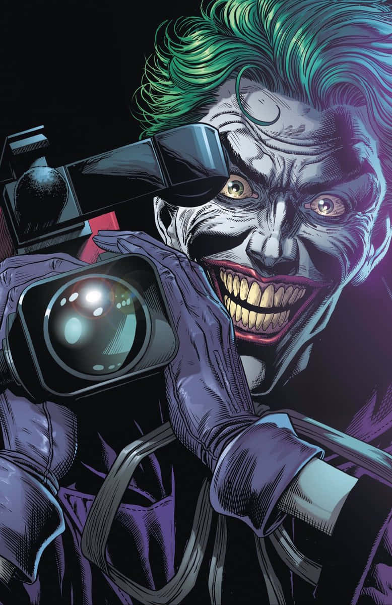 Batman Three Jokers 桌布 壁紙 — 小丑在黑暗背景下，手持相機，露出瘋狂的笑容，擁有鮮豔的綠色頭髮和紫色西裝。