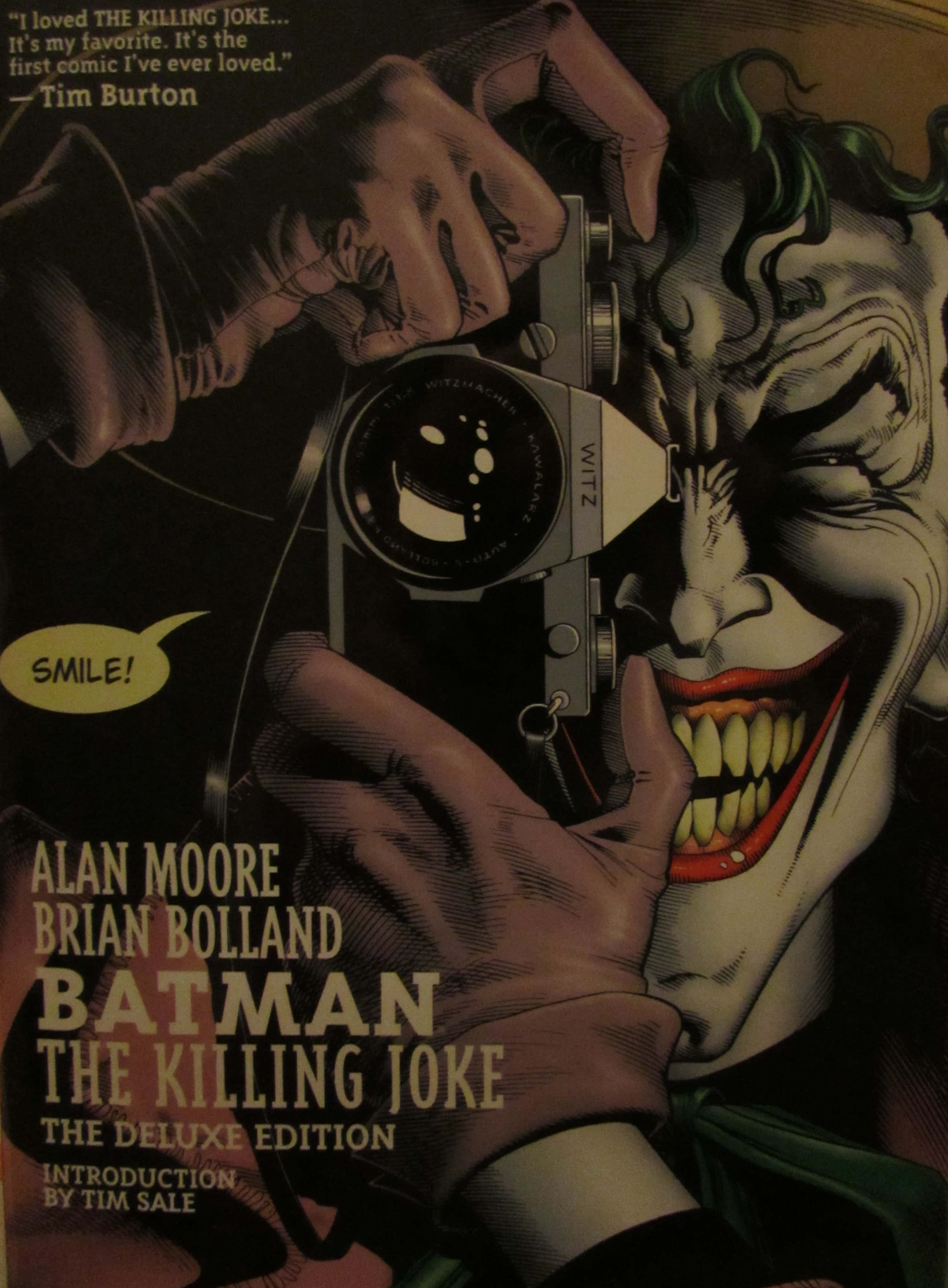 The Killing Joke 桌布 壁紙 — 小丑狂笑著，攝影師透過復古相機鏡頭捕捉他扭曲的面容。