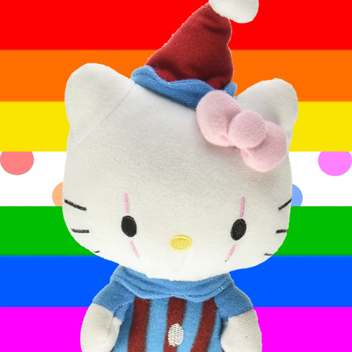 小丑造型Hello Kitty卡通頭像 壁紙 — 一個毛絨Hello Kitty戴着紅色聖誕帽和條紋毛衣，背景是充滿活力的彩虹旗和圓點。
