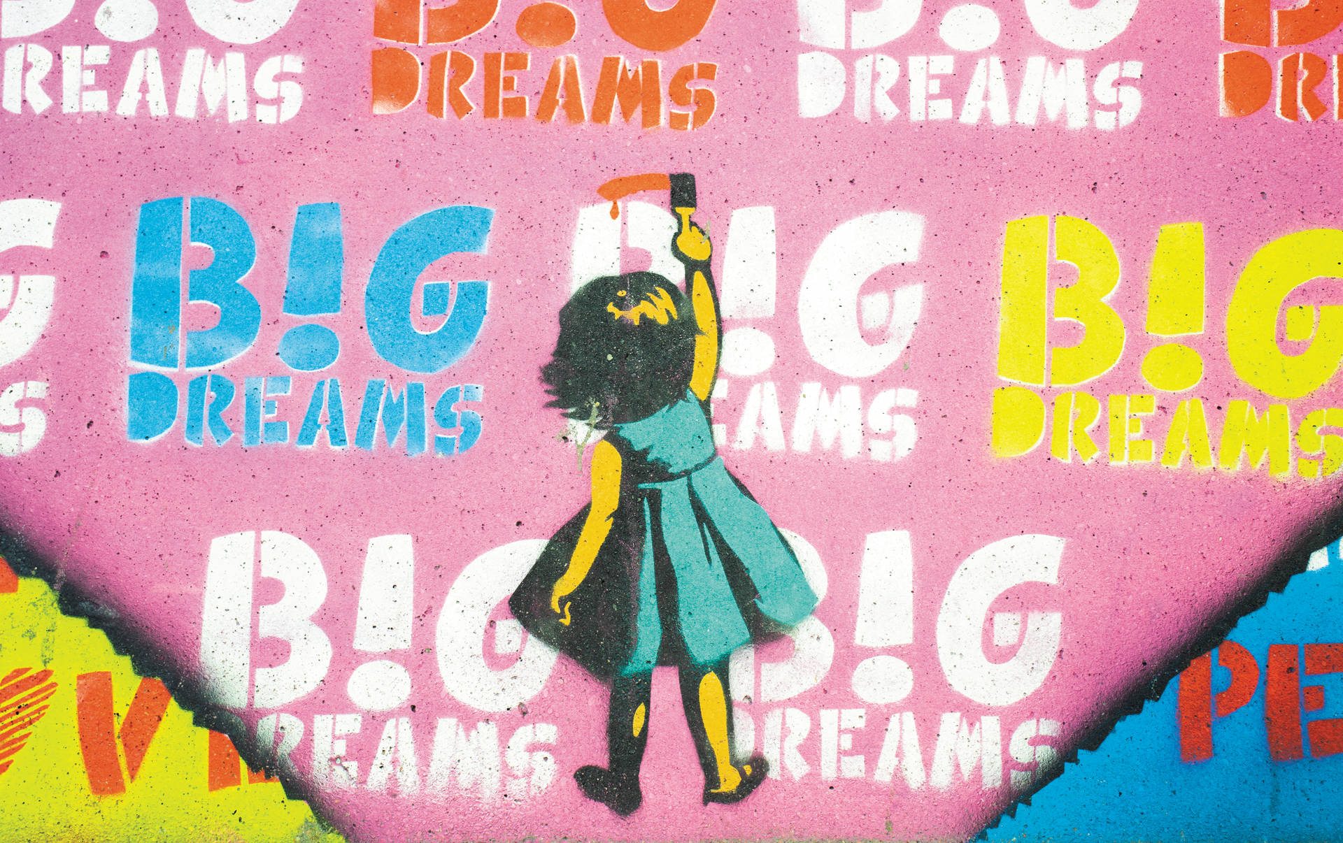 女孩在帶有「Big Dreams」文字的牆上畫塗鴉。