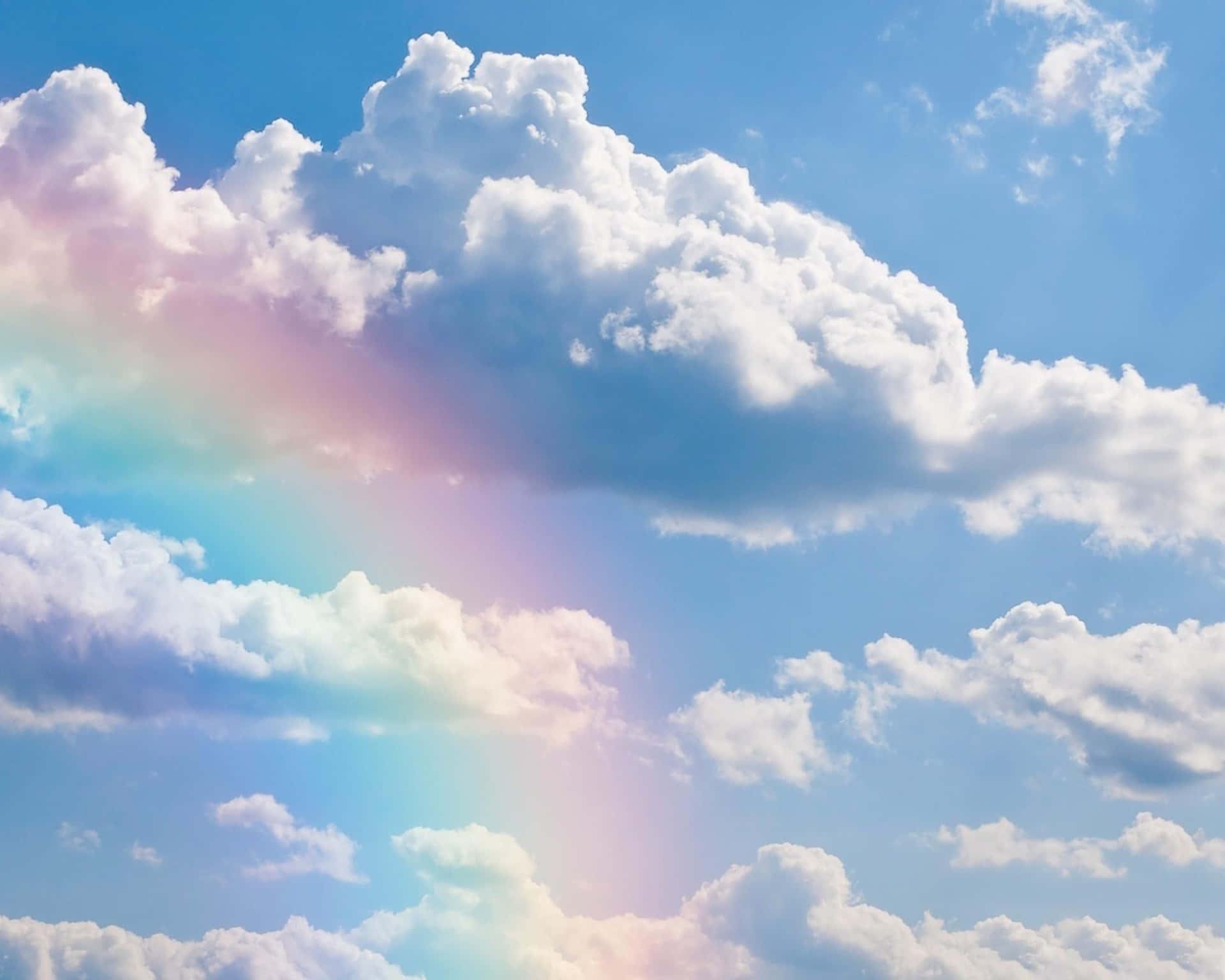 一道彩虹劃過滿是蓬鬆白雲的天空。