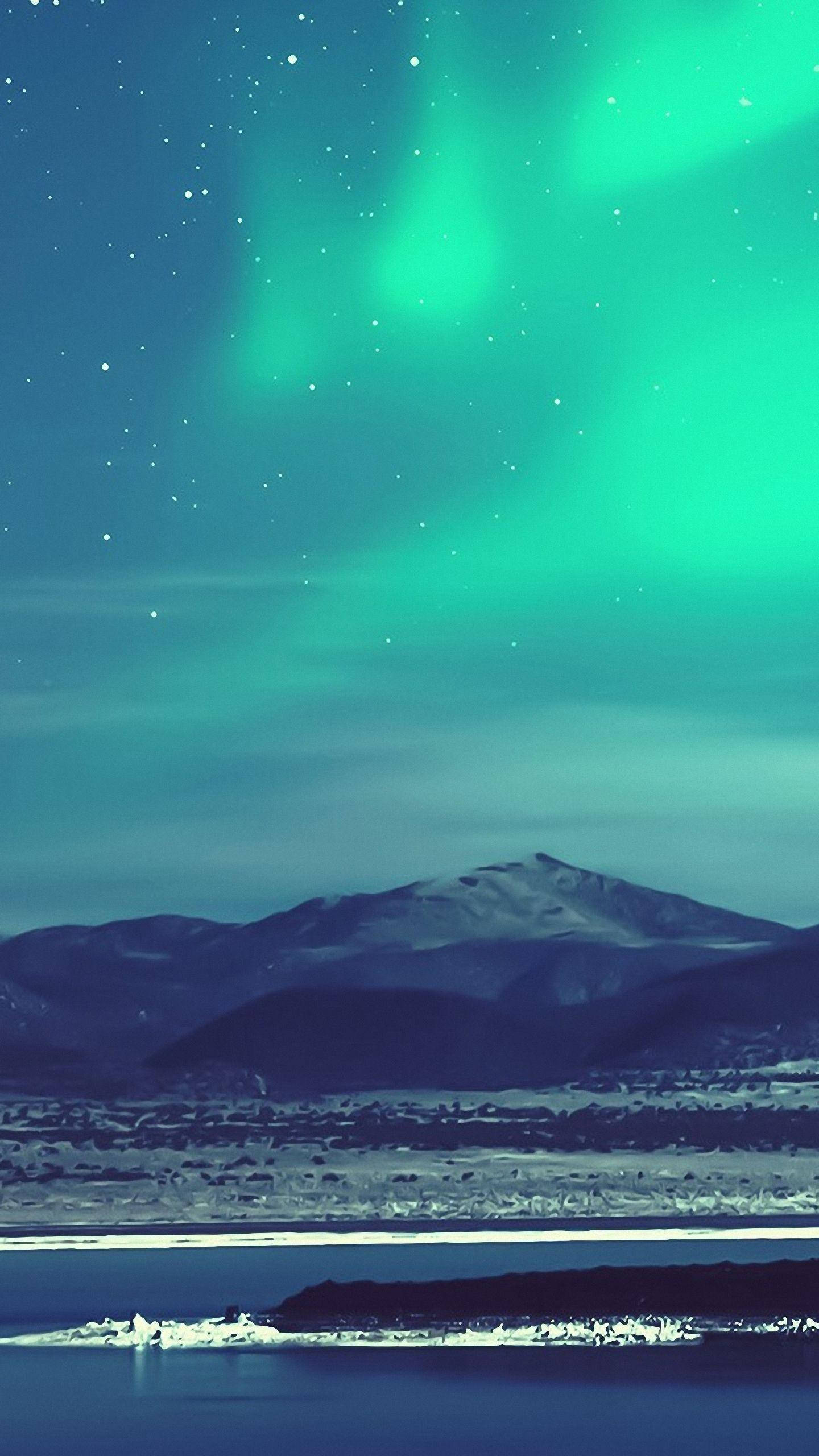 小米山海夜景 壁紙 — 鮮豔的綠色北極光在星空下，在積雪的山脈和冰冷的水面上舞動。