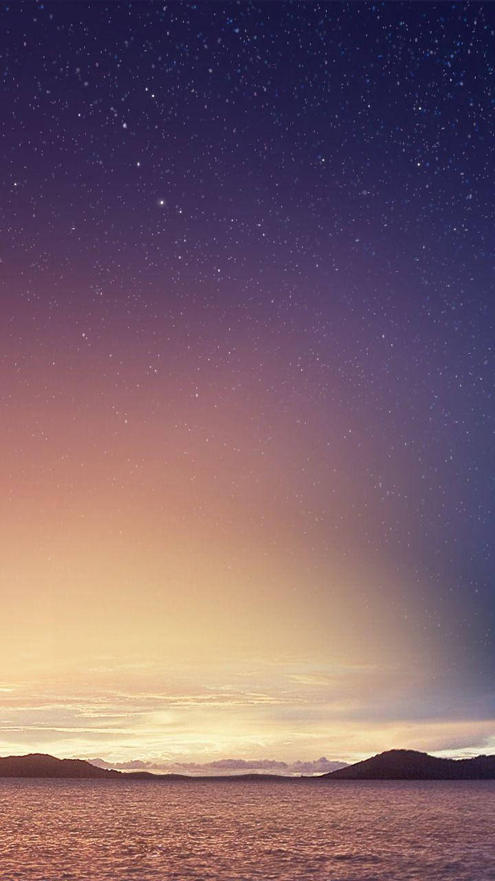 小米繁星滿天 壁紙 — 寧靜的暮色天空從深紫色過渡到溫暖的橙色，籠罩著平靜的海面和遠處的輪廓山丘。