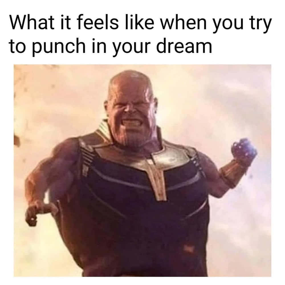小臂版雷神索爾搞笑圖 壁紙 — 來自Marvel漫畫的Thanos，身穿黑金盔甲，握緊拳頭，在模糊的背景前咆哮。