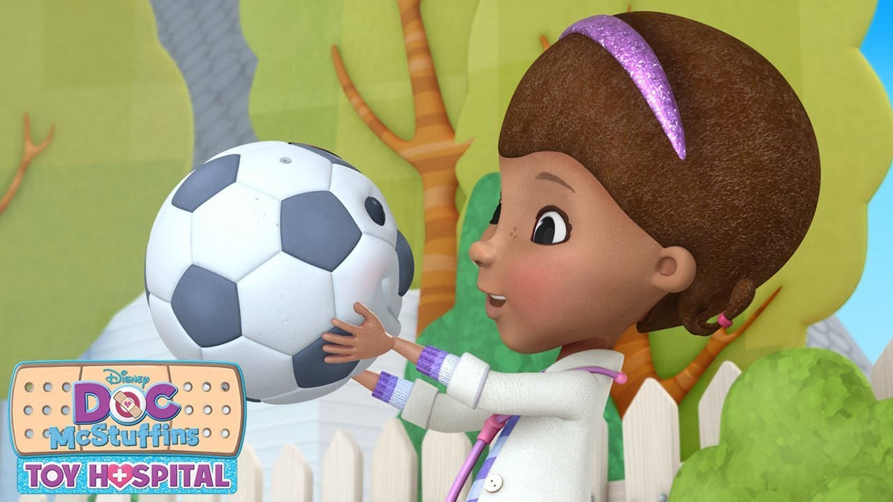 小醫生麥克史東芬斯與爆氣足球波默 壁紙 — Doc McStuffins 喺一個光猛嘅戶外庭院入面，輕輕噉攬住一個足球，周圍有風格化嘅樹木同白色嘅尖樁籬笆。