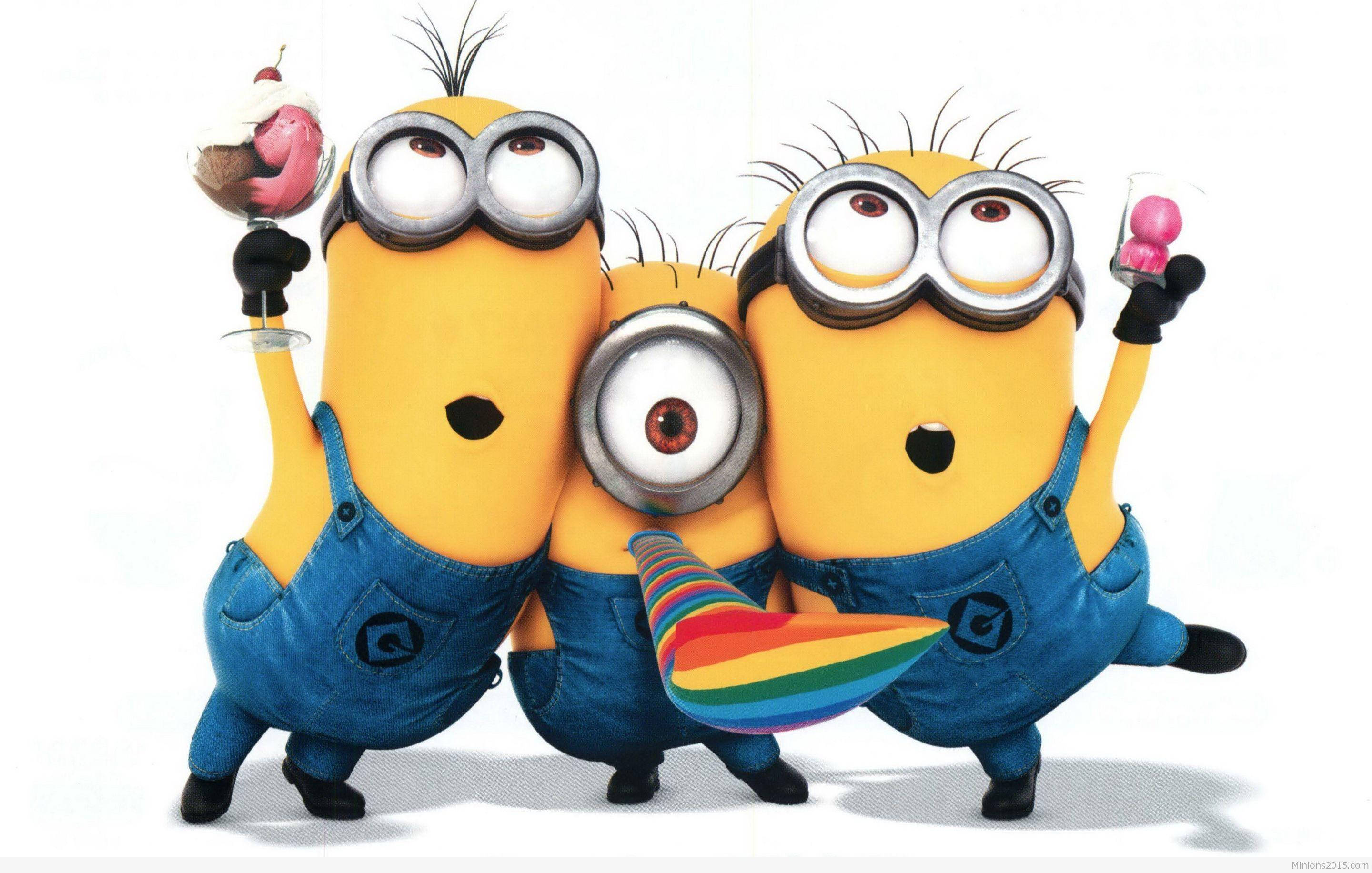 小黃人慶祝搞笑卡通 壁紙 — 三個穿著藍色工裝褲的開心黃色Minions，在白色背景前用彩虹派對喇叭和彩色飲料慶祝。