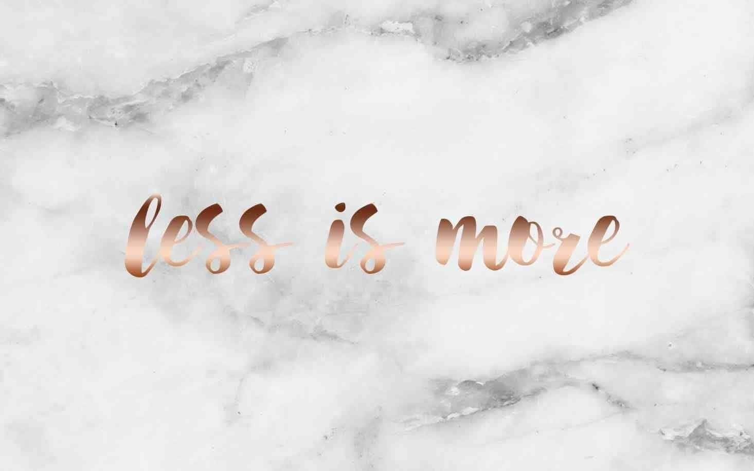 白色大理石背景上的玫瑰金色 Less is more 文字