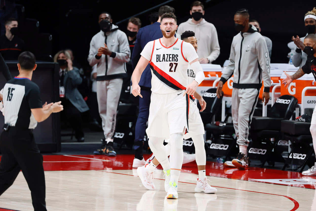 尤素福·努爾基奇2021年擊敗丹佛金塊隊 壁紙 — 一名身穿白色Blazers球衣、背號27的籃球運動員在拋光球場上慶祝，隊友和工作人員在他周圍反應。