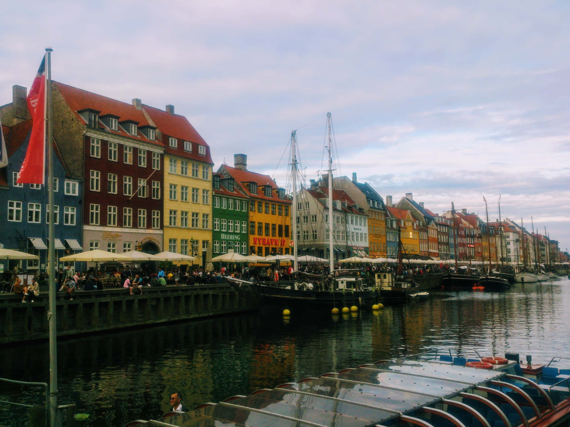 運河旁色彩繽紛的歷史建築，有船隻和人們在戶外咖啡館。