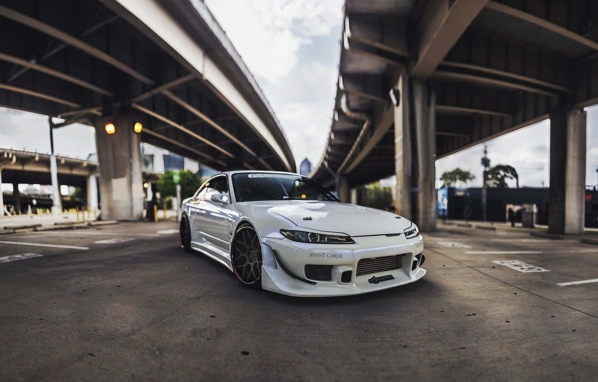 尼桑Silvia S15 —— 調校車迷的真正經典 壁紙 — 一輛時尚的白色跑車配備定制輪圈，停在混凝土高架橋下，光線效果戲劇性。