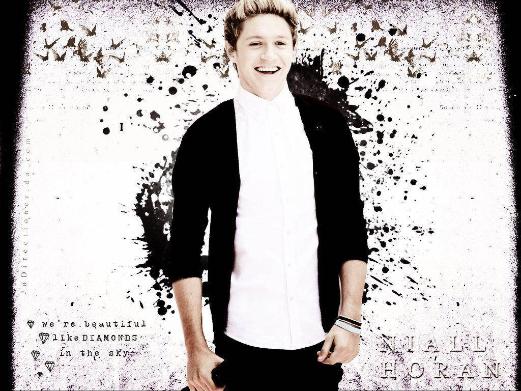 Niall Horan 穿著白色襯衫和黑色開襟衫，在藝術潑濺背景中微笑。