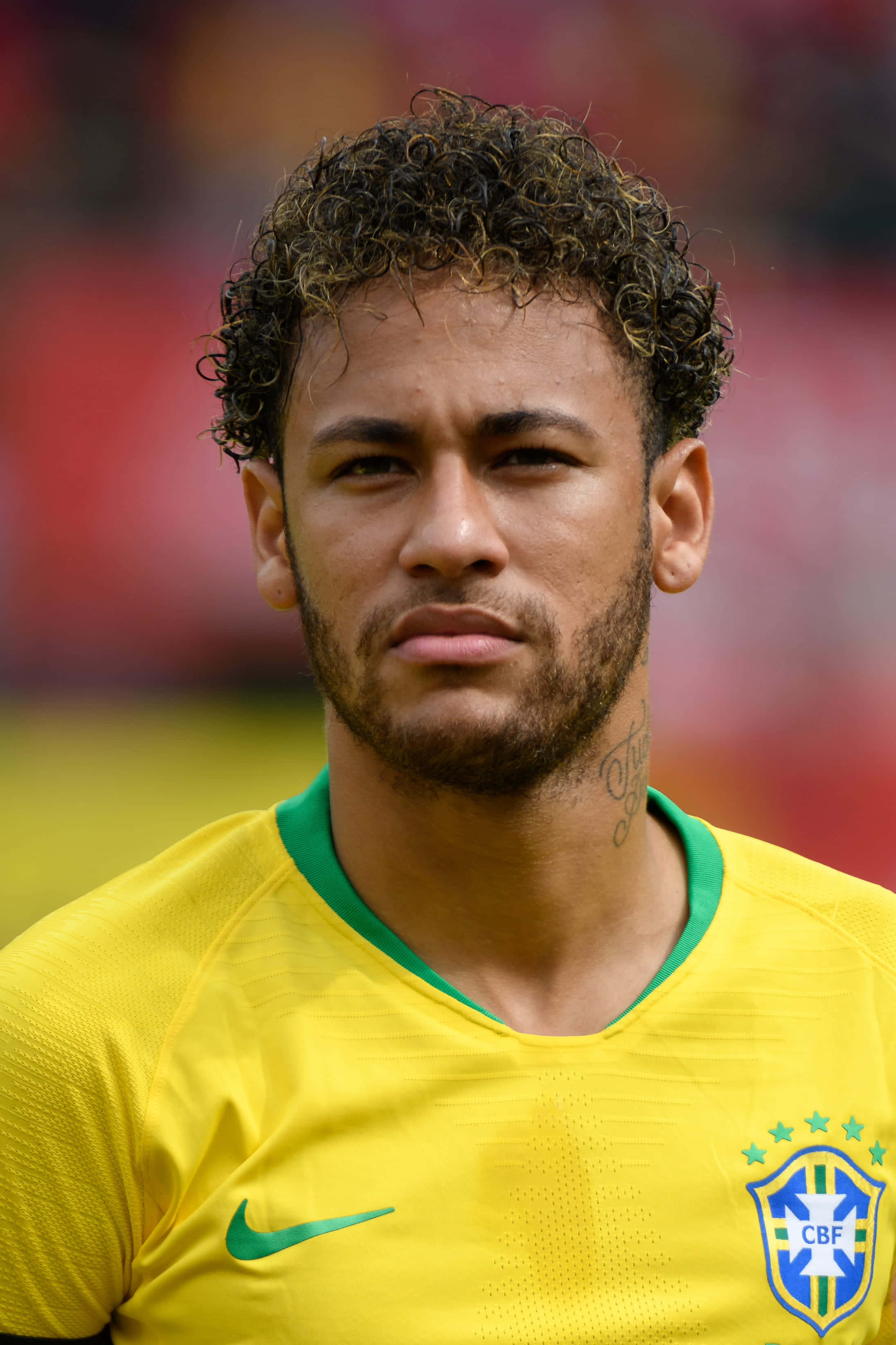 Neymar 桌布 壁紙 — 尼馬身穿巴西黃色足球球衣，帶有綠色點綴和CBF徽章的近距離肖像。