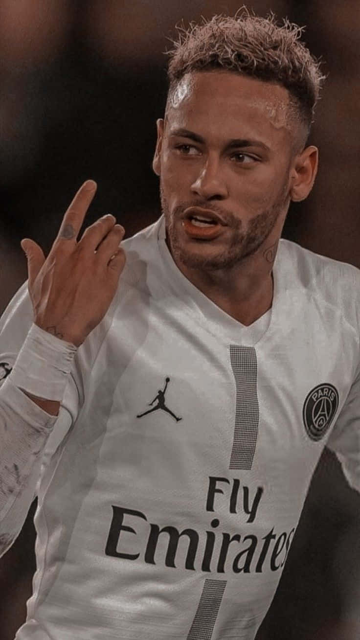 Neymar 桌布 壁紙 — 尼馬身穿白色巴黎聖日耳曼球衣，在球場燈光下比賽時做出手勢的特寫。