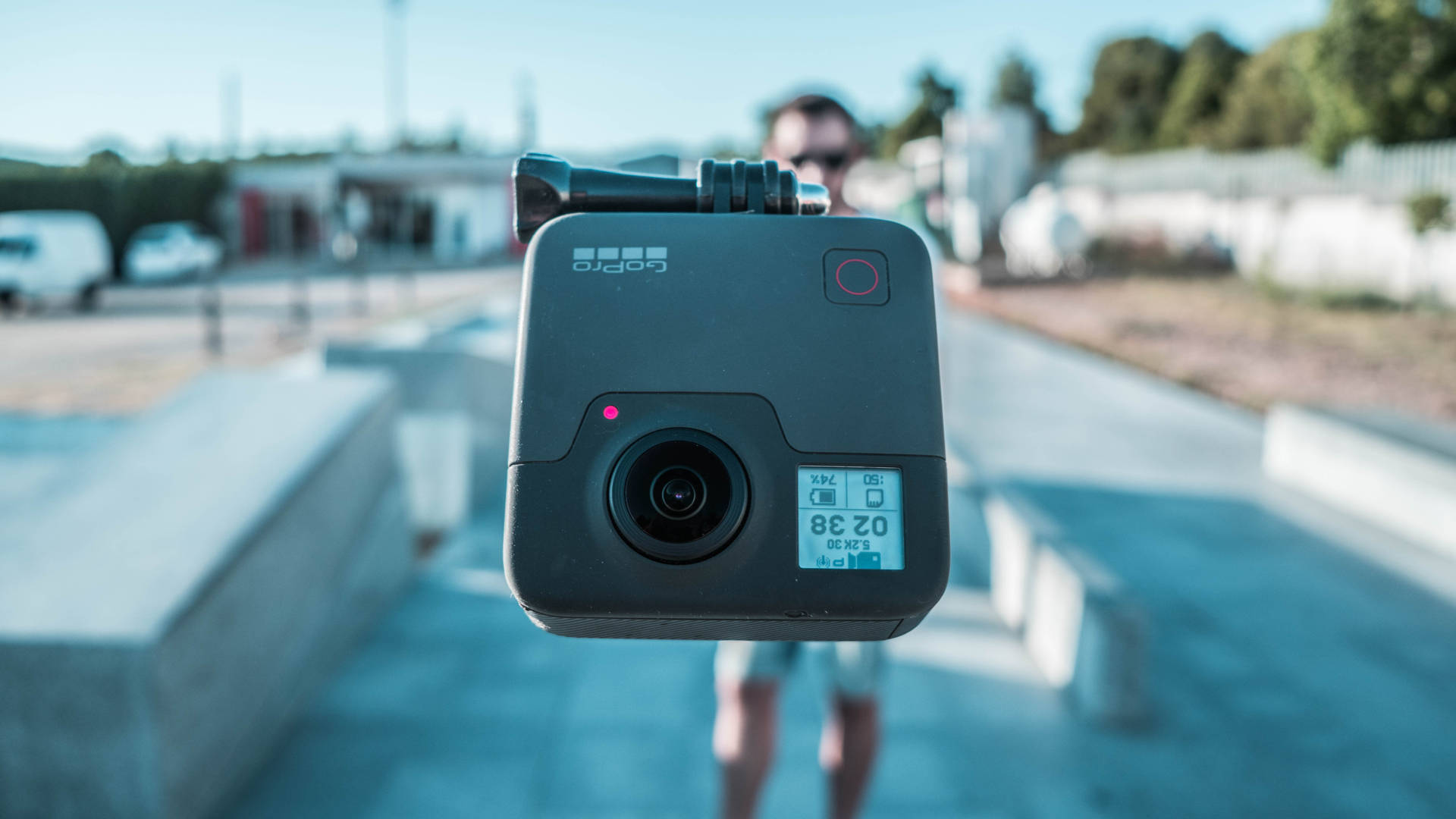 一個GoPro相機指向觀看者，背後有一個人失焦。